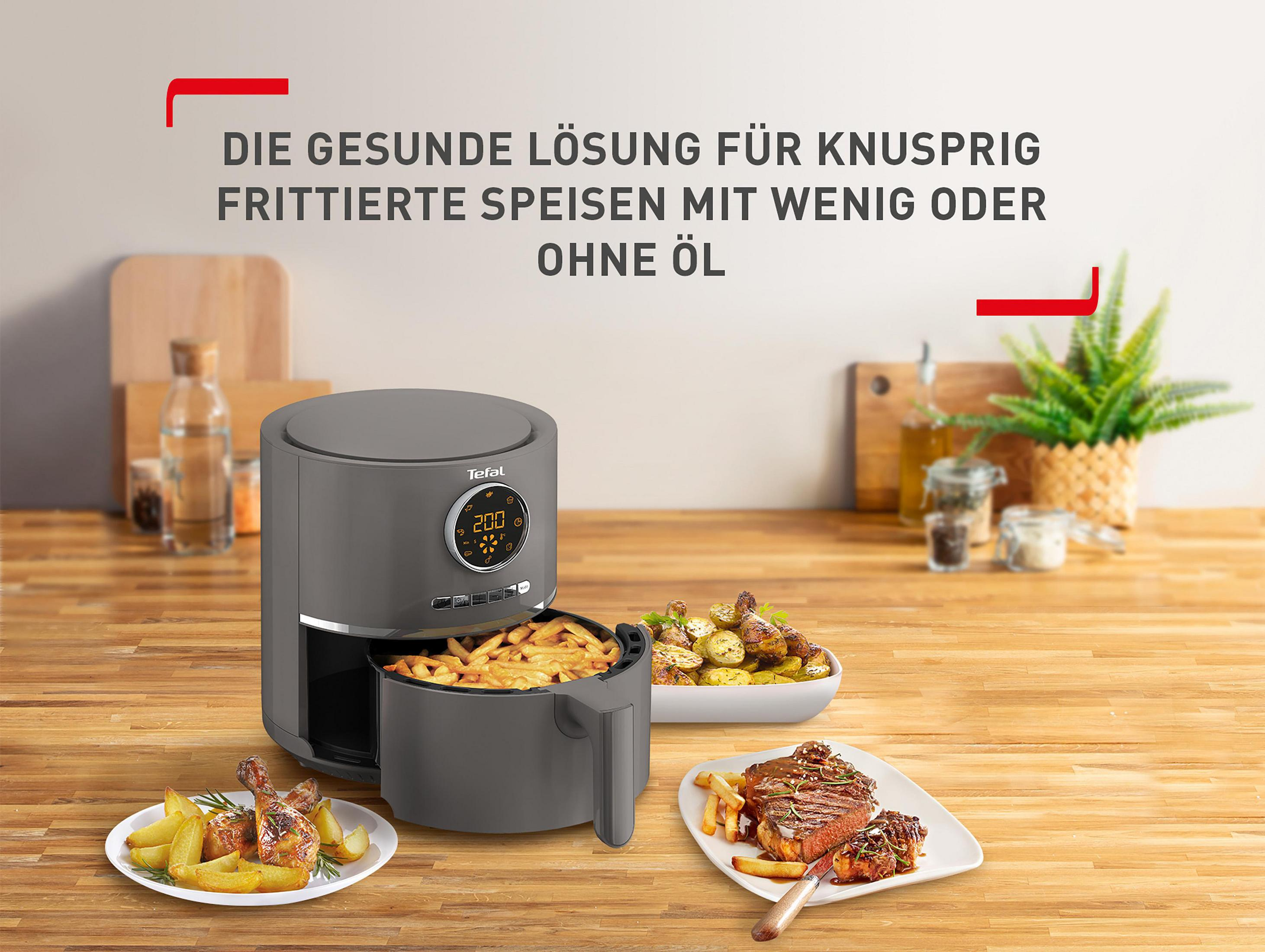 Frytkownica beztłuszczowa z jedzeniem na talerzach. Tekst powyżej mówi: "Zdrowe rozwiązanie dla smażonych potraw".