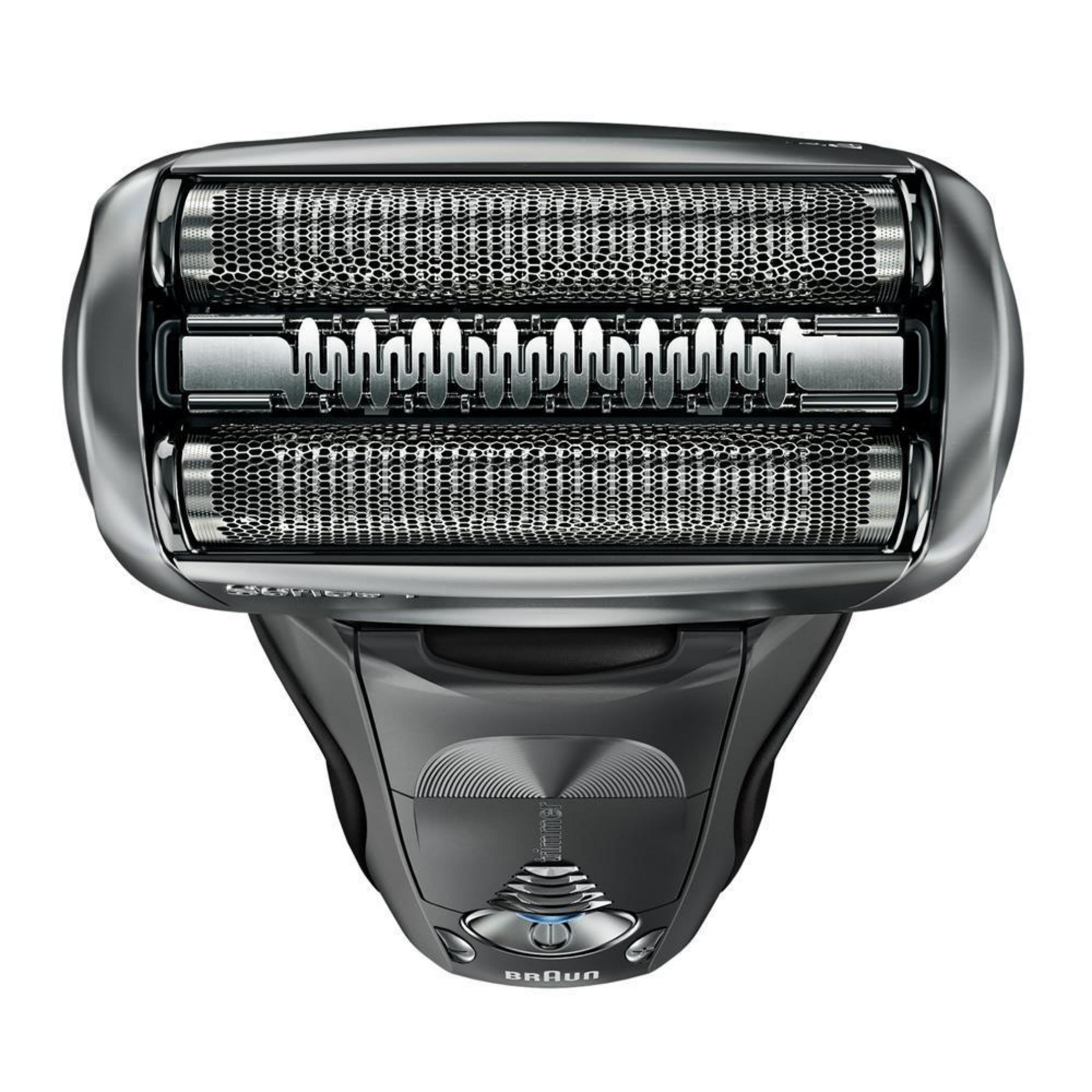 Primo piano di un rasoio elettrico grigio, vista dall'alto, mostra lame e manico. Logo Braun visibile.