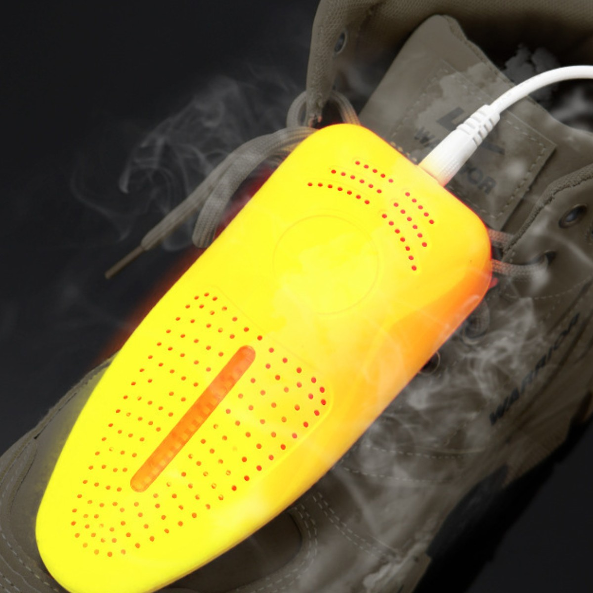 Gelber Schuhtrockner in einem Stiefel, dampfend, mit weißem Netzkabel.