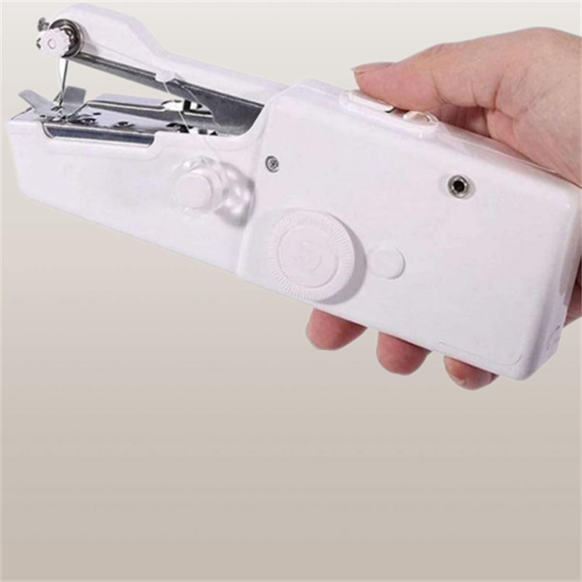 Eine weiße Handnähmaschine wird von einer Hand gehalten.