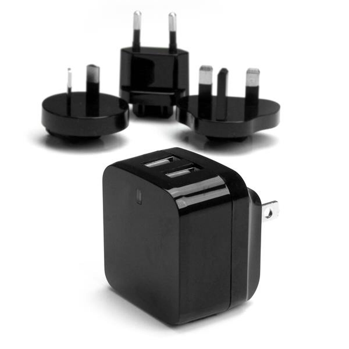 Cargadores USB negros con diferentes adaptadores de enchufe. Enfoque en el cargador frontal con dos puertos.