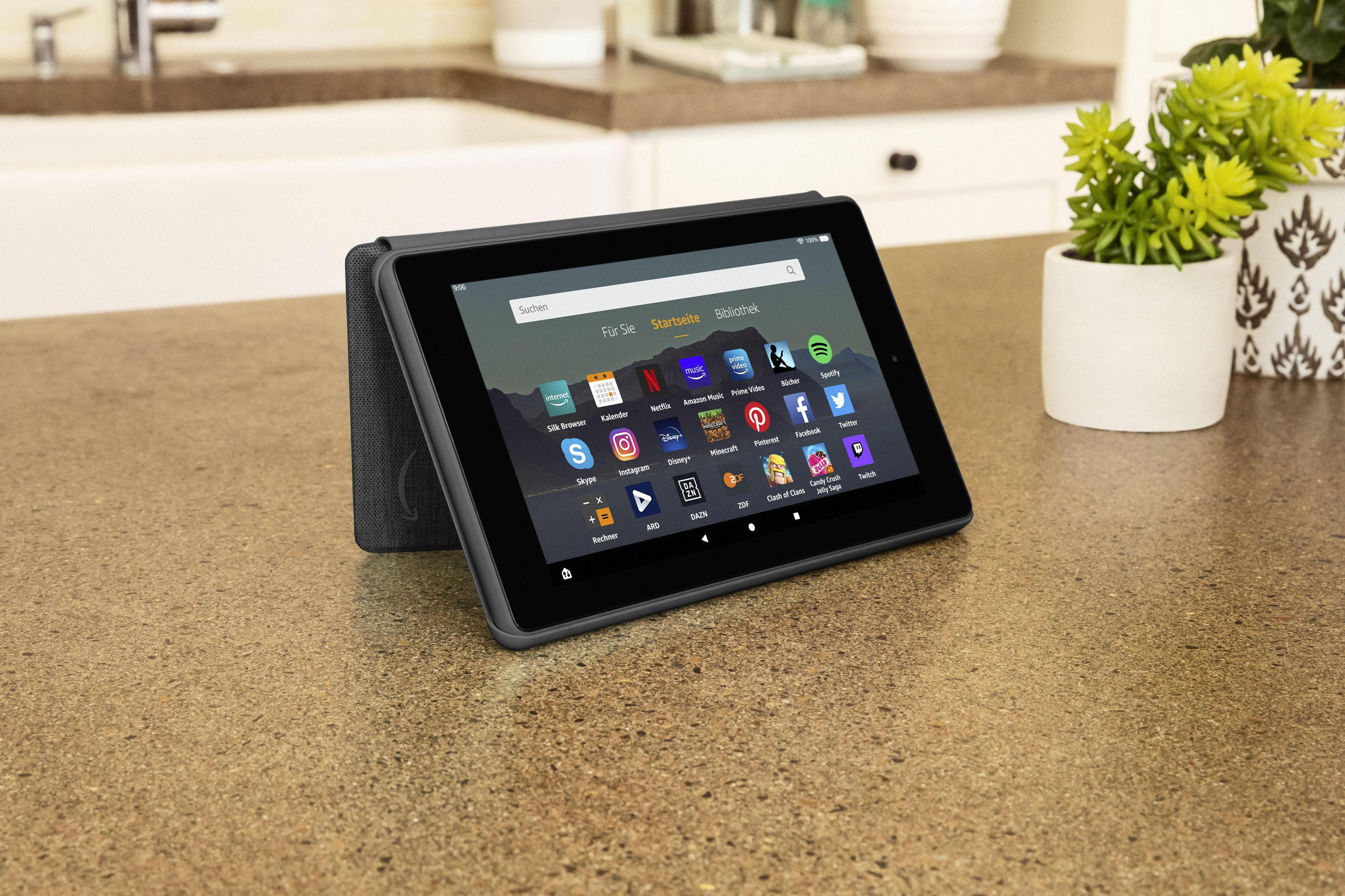 Ein Tablet auf einer Arbeitsplatte. Der Bildschirm zeigt einen Startbildschirm mit App-Symbolen.
