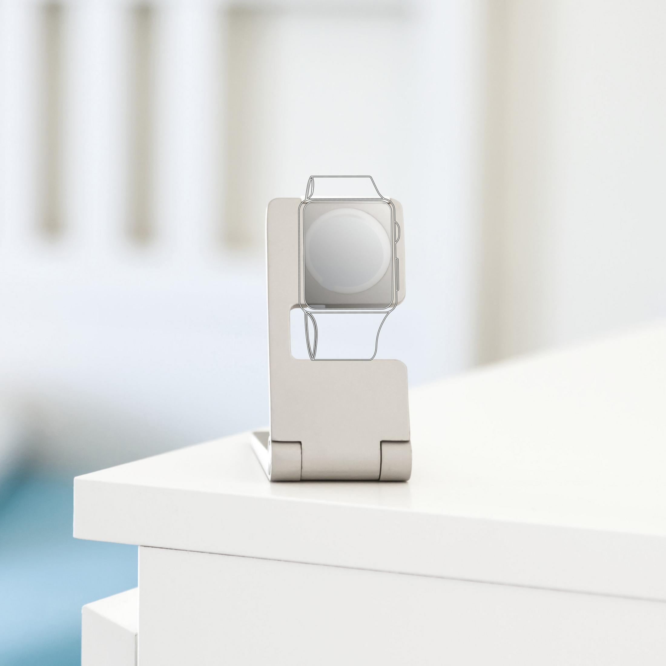 Eine weiße Uhr auf einem Ständer. Die Uhr ist silber, der Ständer grau. Weißer Hintergrund.