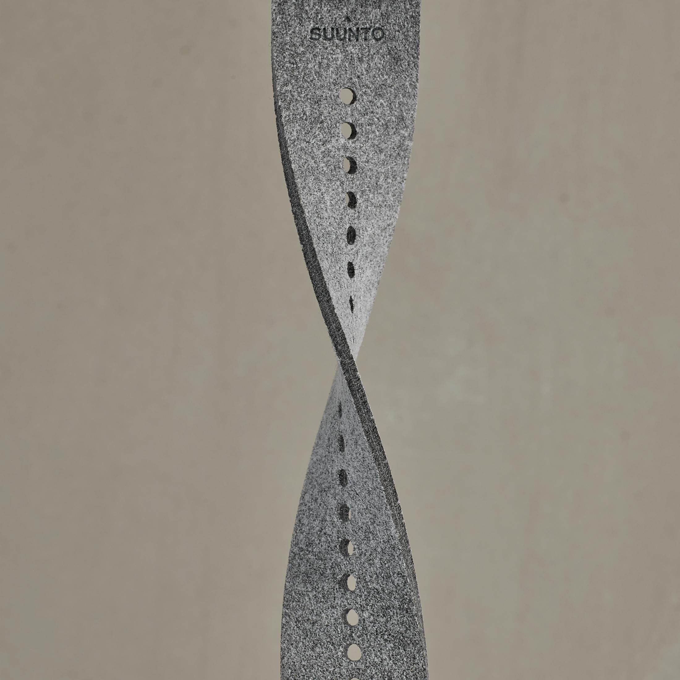 Szary pasek do zegarka Suunto w skręconej konstrukcji. Nazwa marki jest nadrukowana u góry.