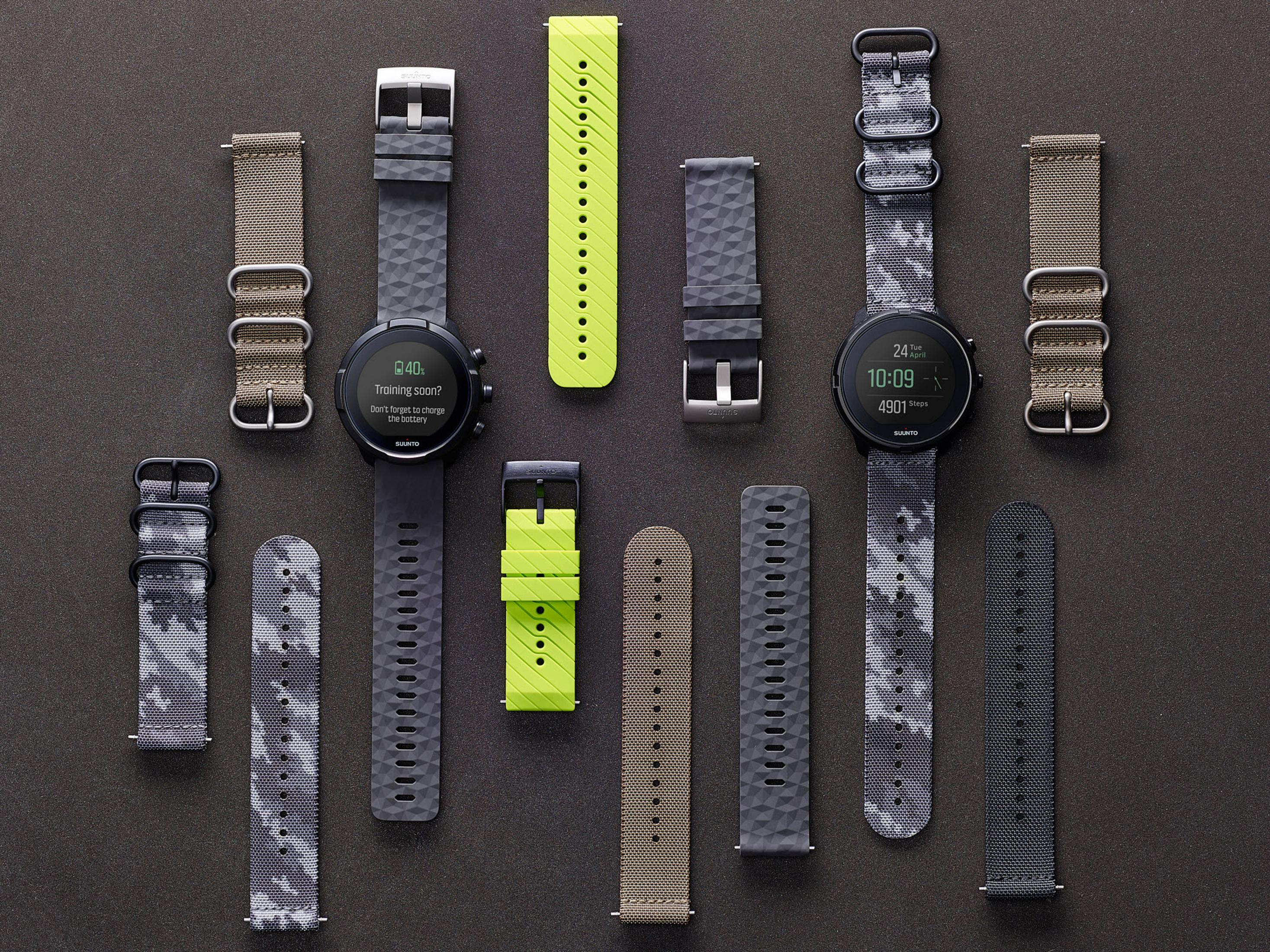 Dwa smartwatche z paskami w różnych kolorach i wzorach ułożone na ciemnej powierzchni.