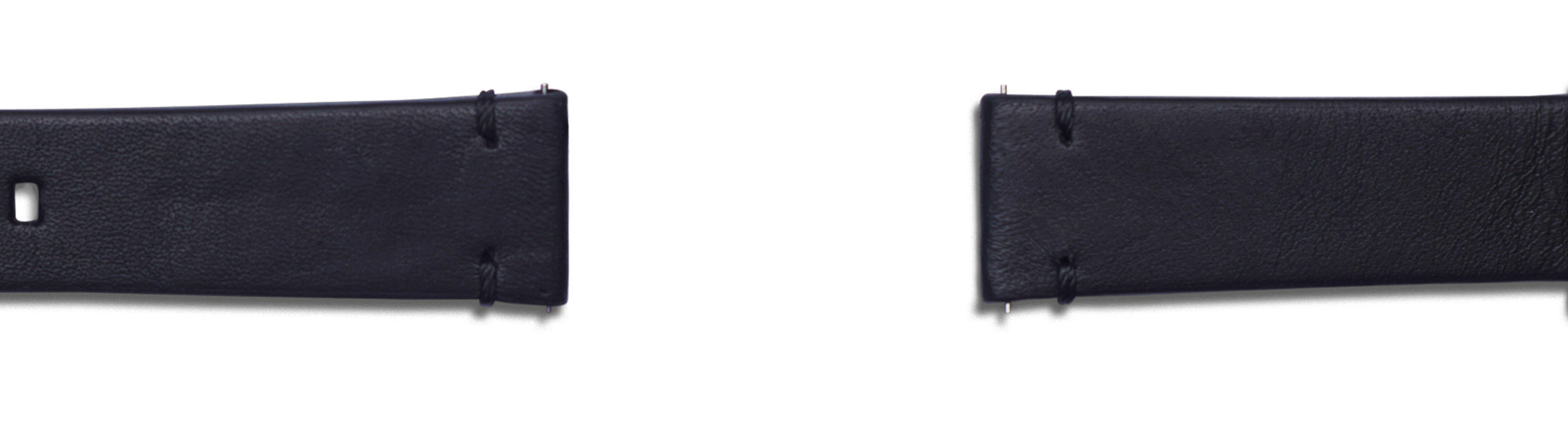 Zbliżenie dwóch czarnych skórzanych pasków na białym tle, równoległe, z metalowymi zapięciami.