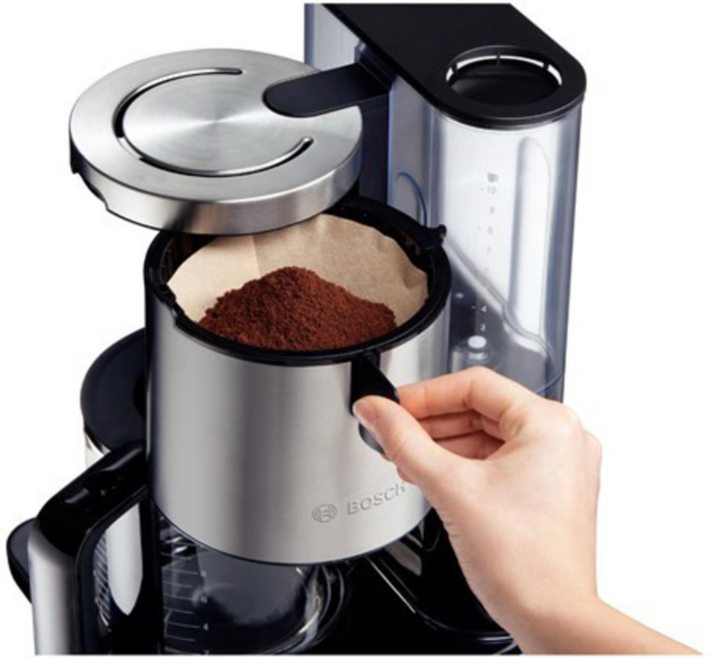 Osoba wsypująca zmieloną kawę do filtra w ekspresie do kawy.