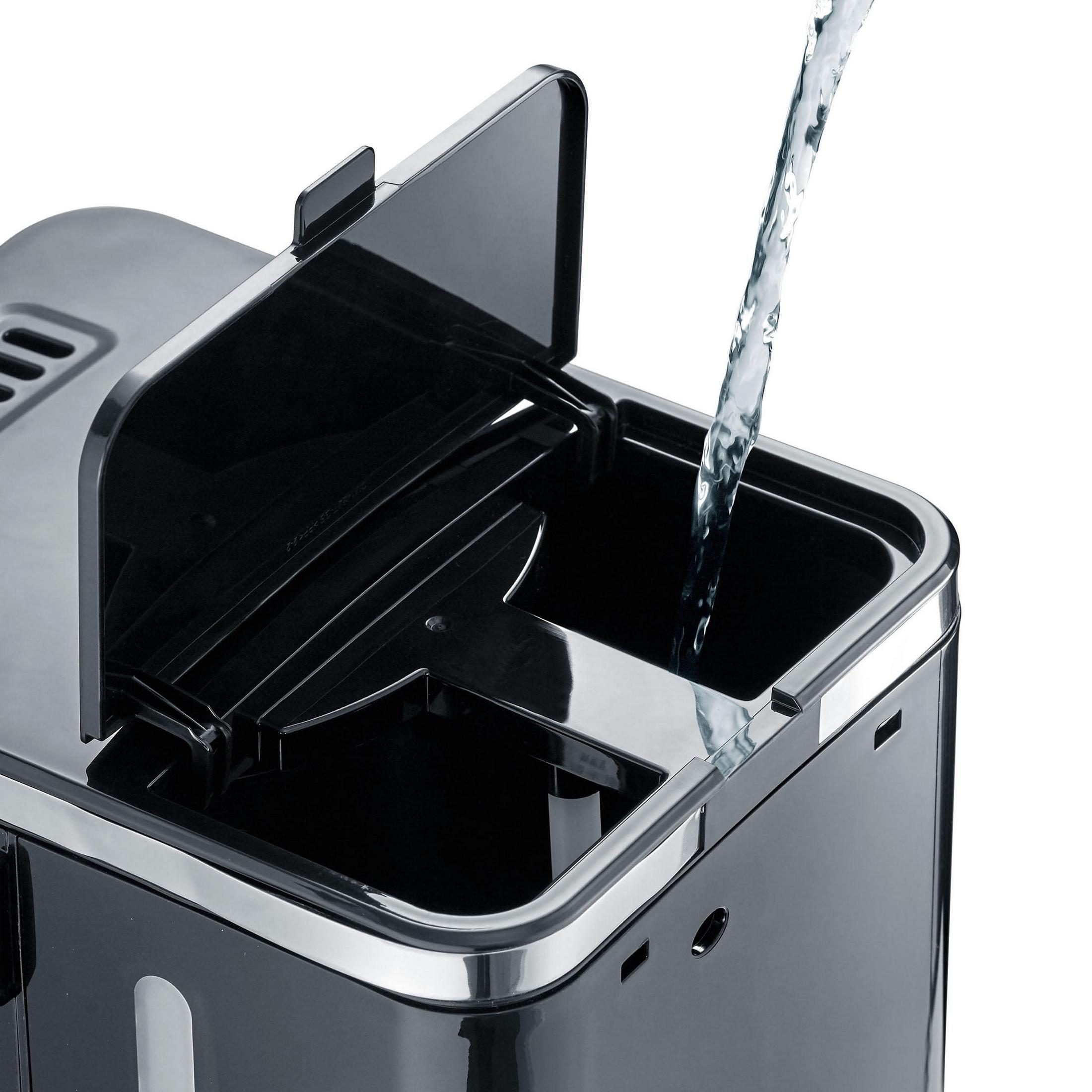 Czarny ekspres do kawy z wodą wlewaną do zbiornika. Pokrywa jest otwarta.