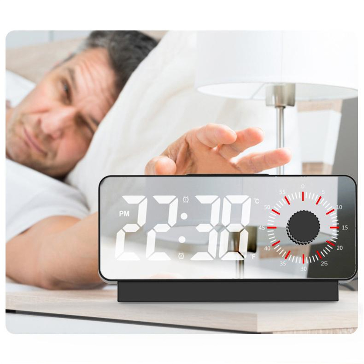 Wecker mit Anzeige 22:30 Uhr. Ein Mann greift nach der Uhr.