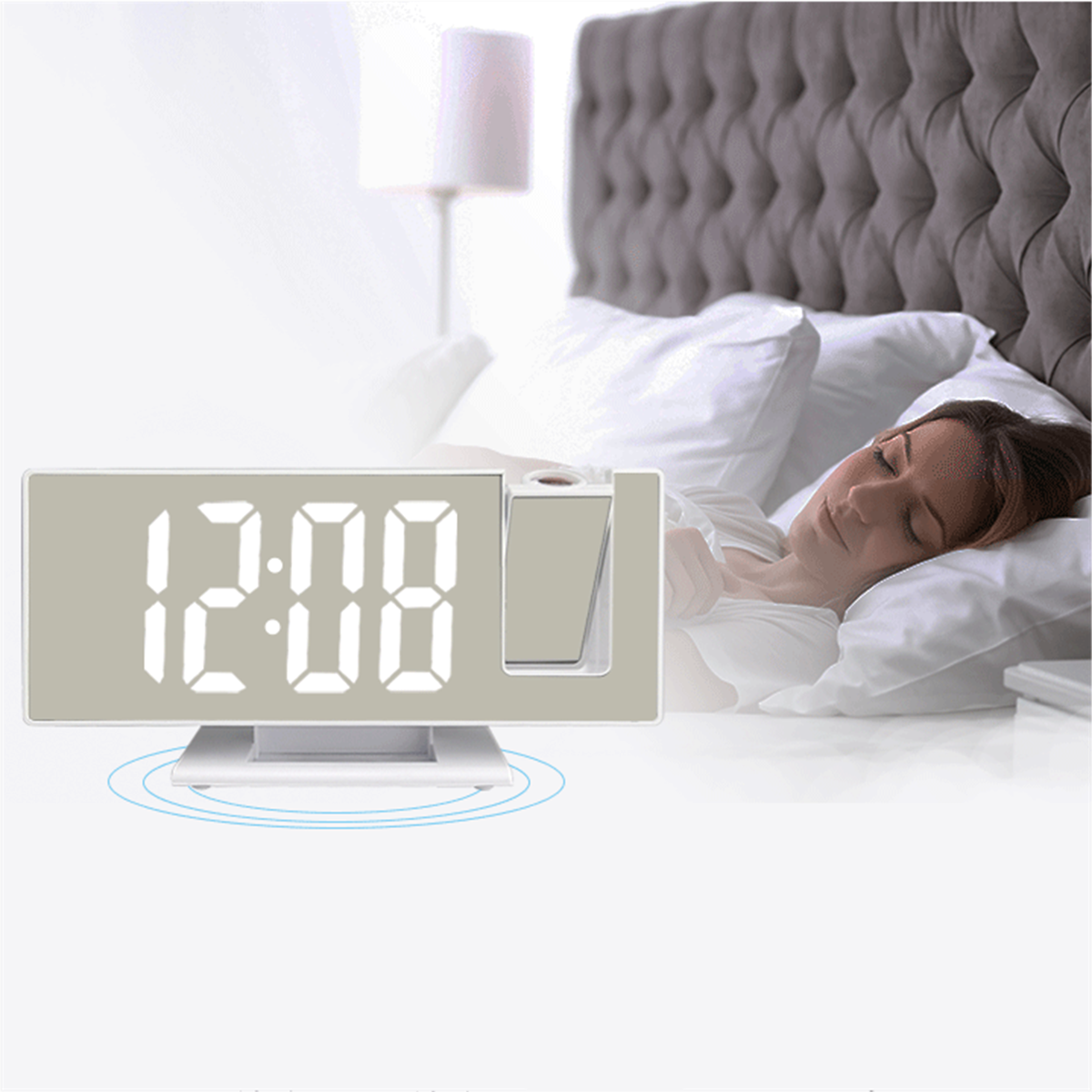 Digitaler Wecker, der die Zeit anzeigt. Frau schläft im Bett dahinter.