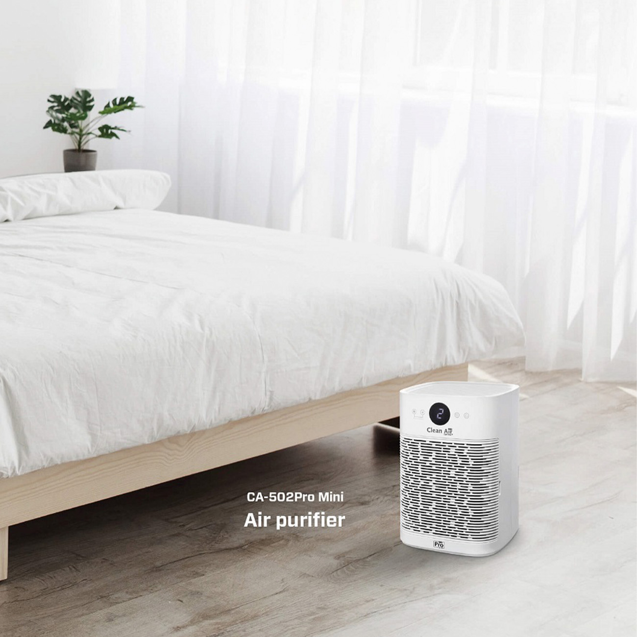 Purificatore d'aria bianco vicino a un letto, stanza con lenzuola bianche, pianta e finestra.