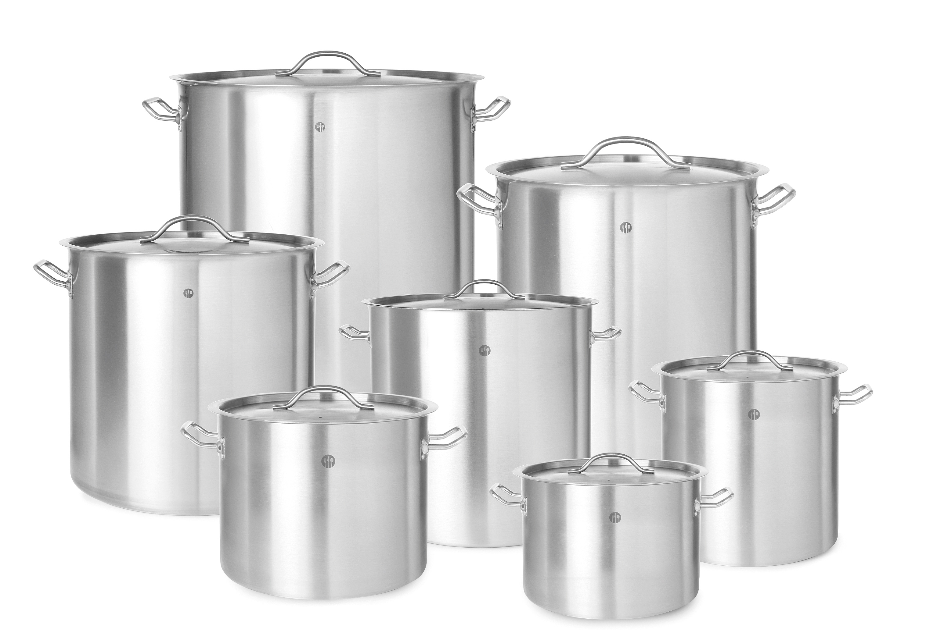 Set di pentole in acciaio inox con coperchi di varie dimensioni, su superficie bianca.