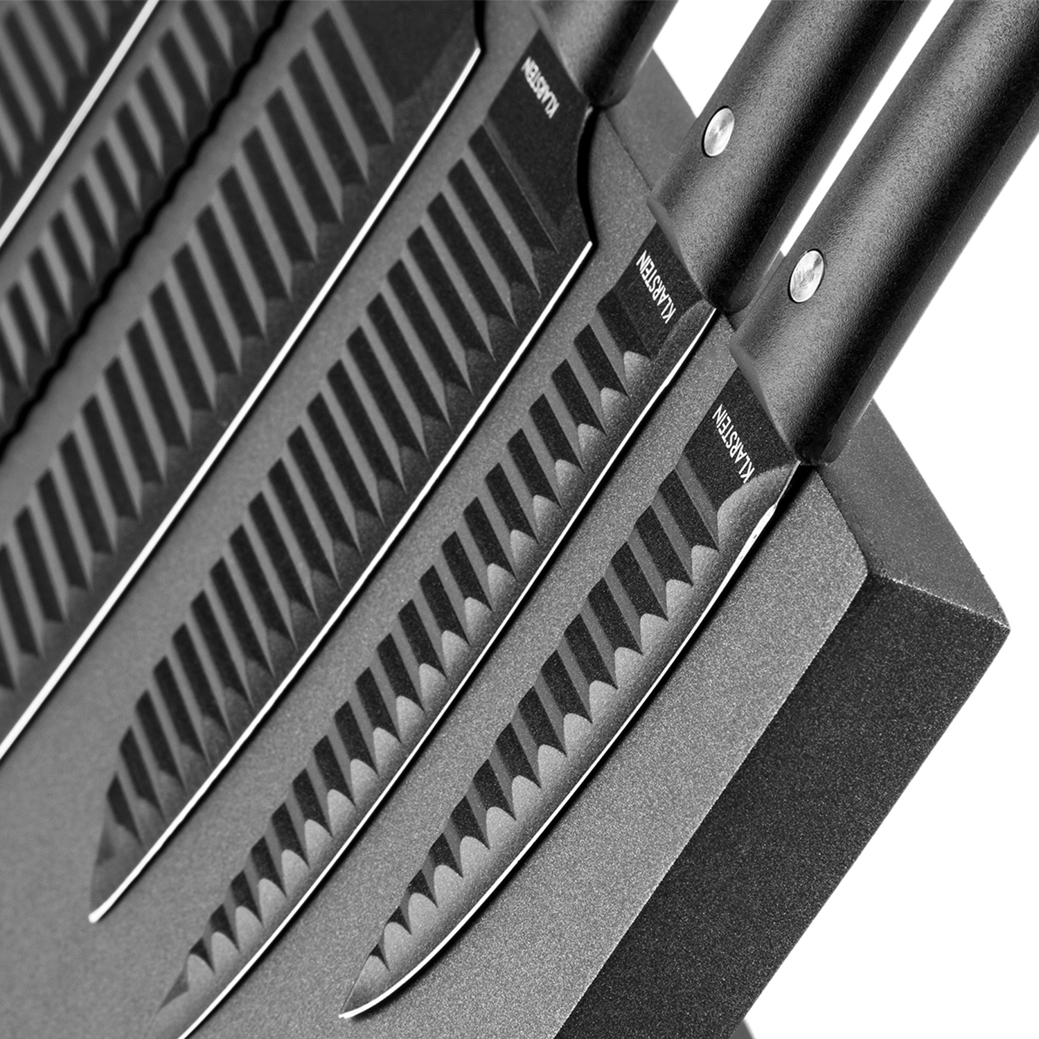Satz schwarzer Messer in einem Block. Klingen sind sichtbar, mit gezahnten Kanten. Schwarzer Griff.