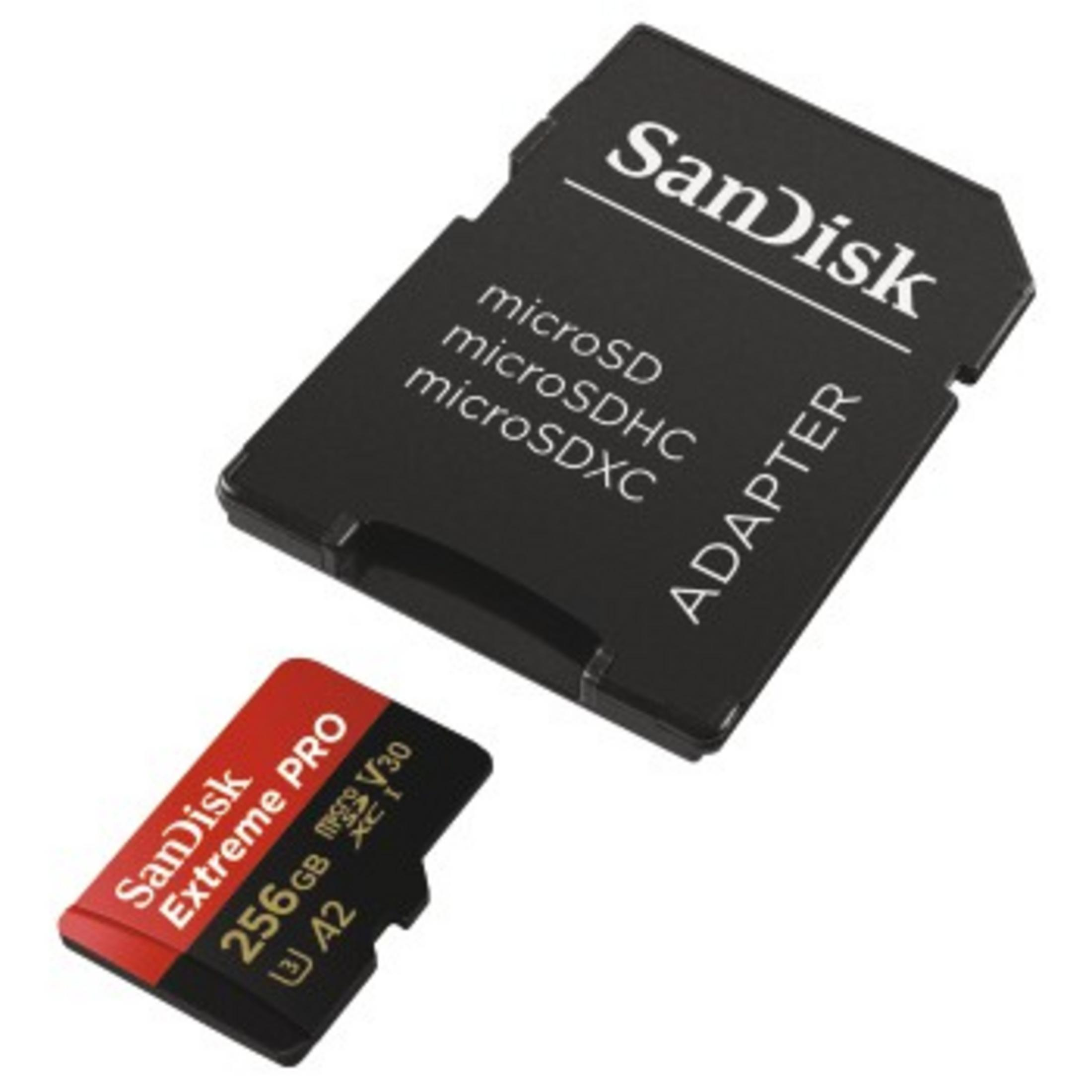 Una tarjeta microSD y adaptador Sandisk. La tarjeta es roja y negra, el adaptador es negro.