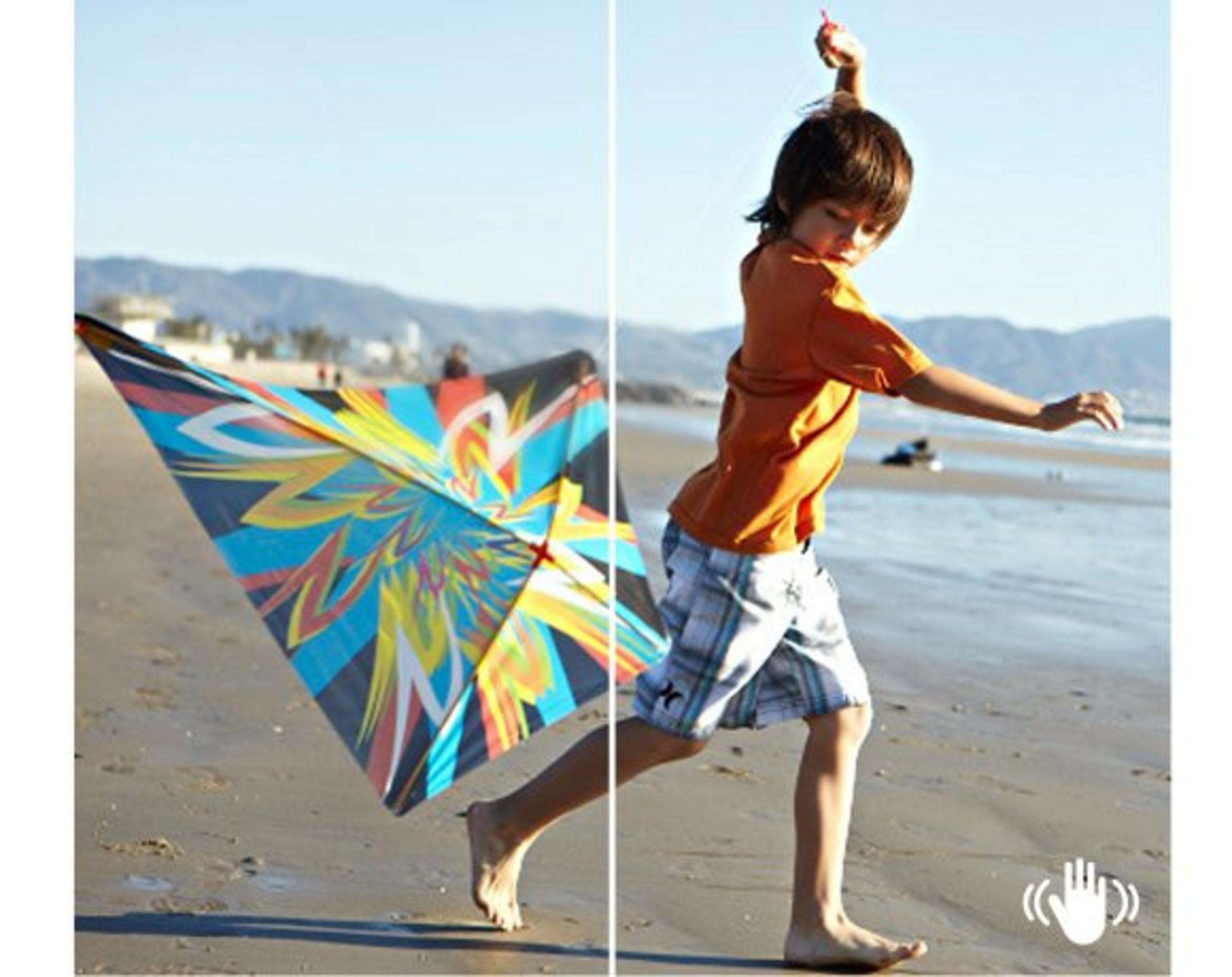 Ein Junge rennt am Strand mit einem bunten Drachen. Der Drachen hat ein sternartiges Design.