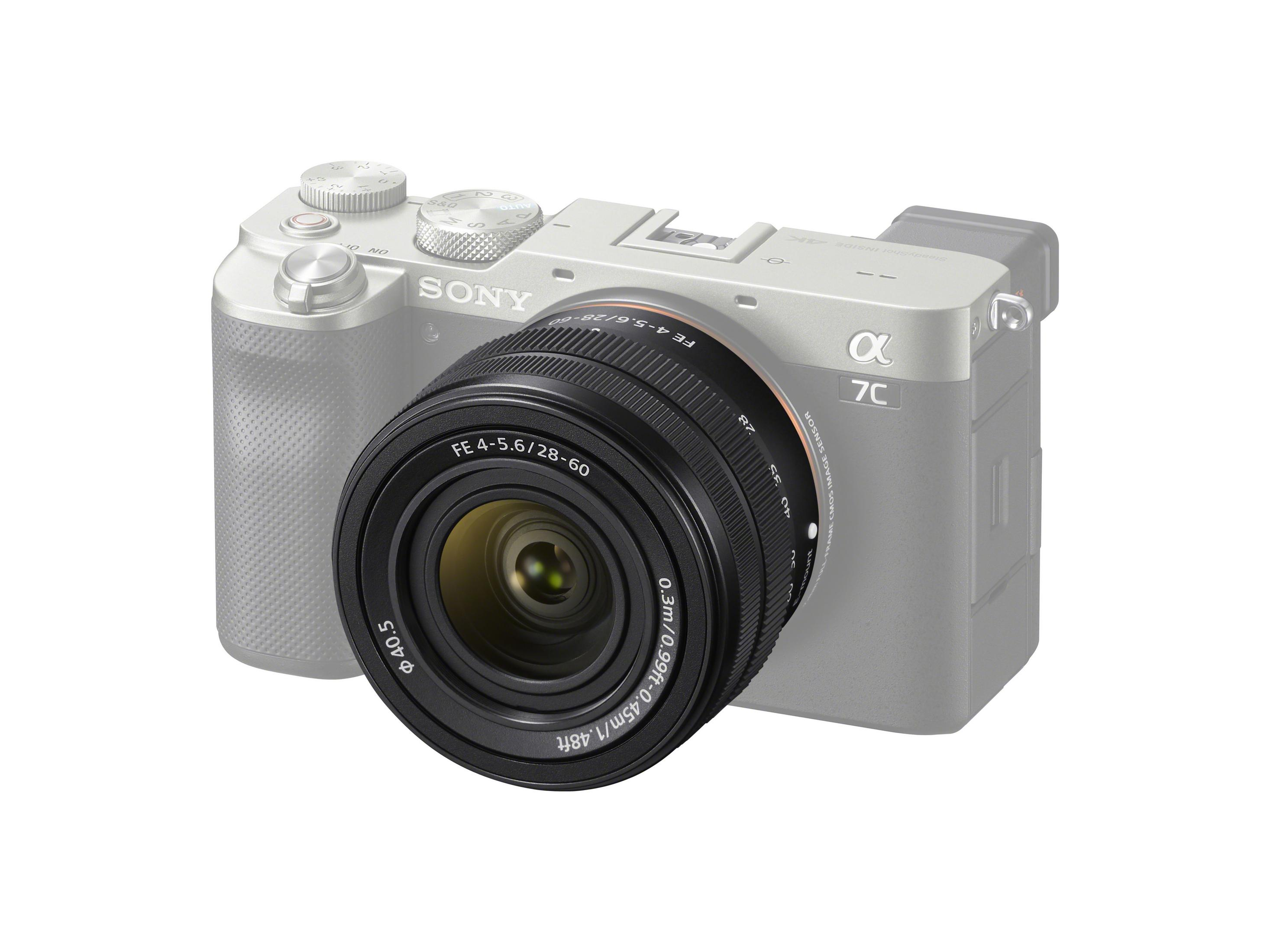 Srebrny aparat Sony z czarnym obiektywem. Obiektyw jest głównym elementem obrazu.