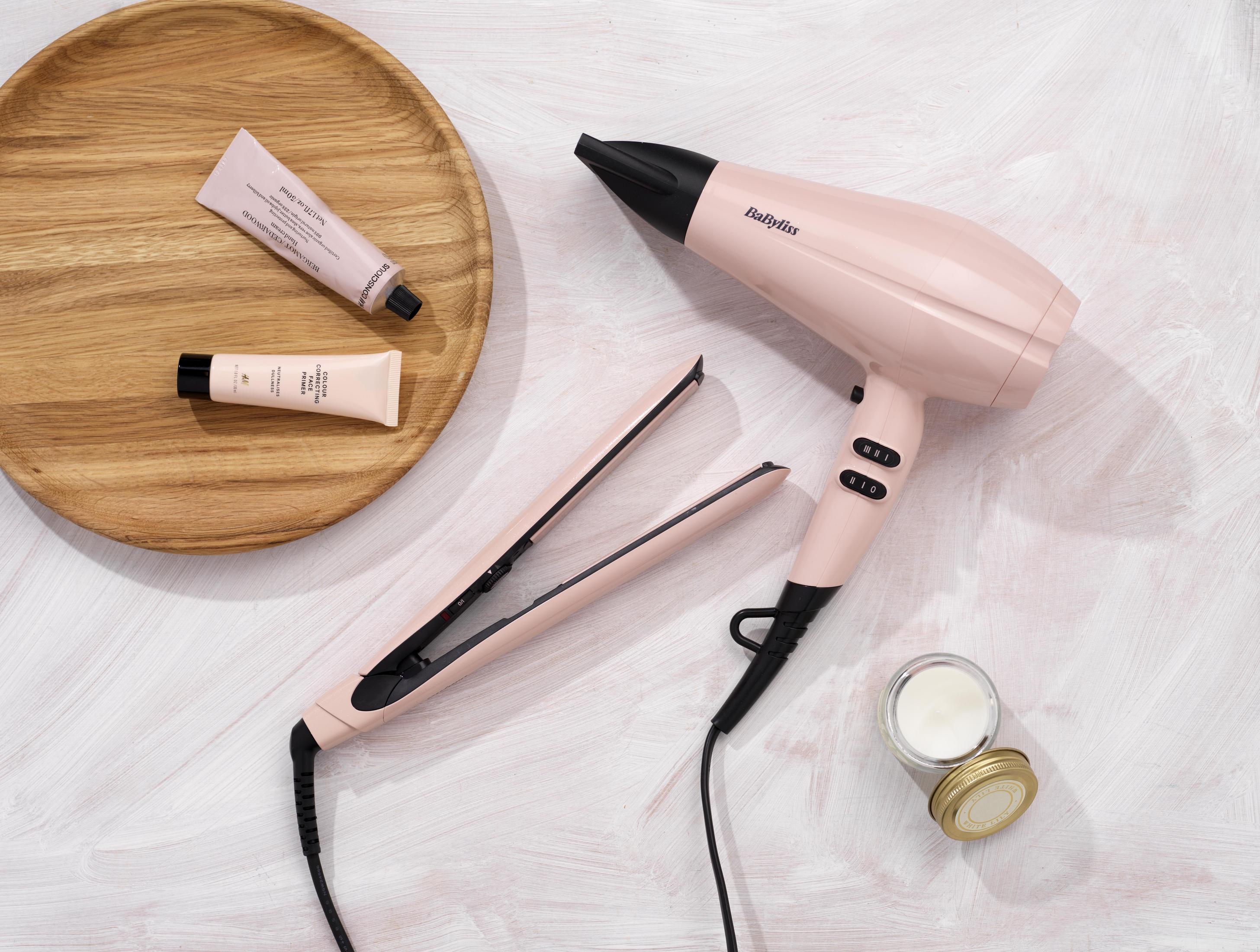 Narzędzia do stylizacji włosów: suszarka, prostownica i produkty do pielęgnacji skóry.