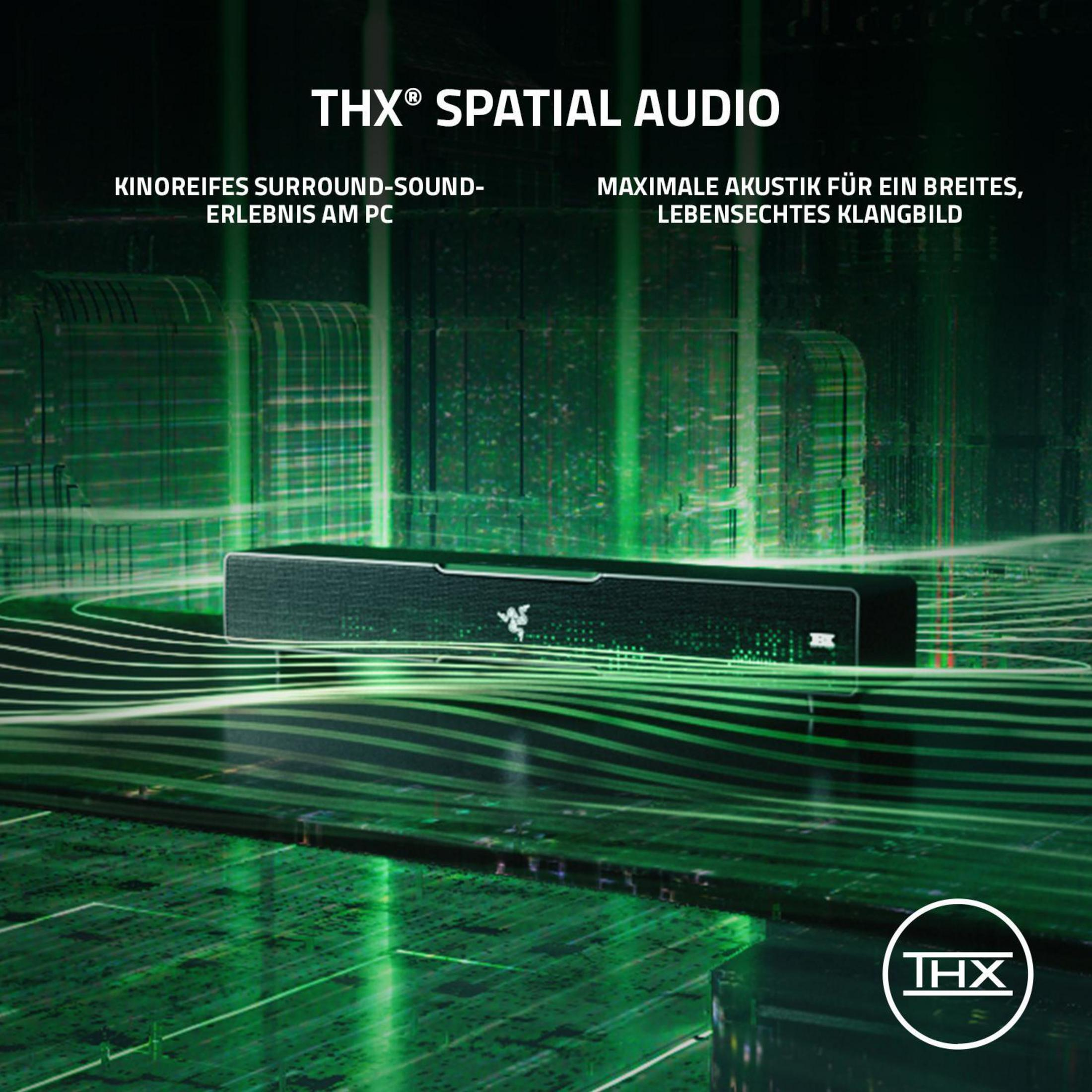 Czarny soundbar Razer z zielonymi światłami, tekstem THX Spatial Audio, na zielonej powierzchni.