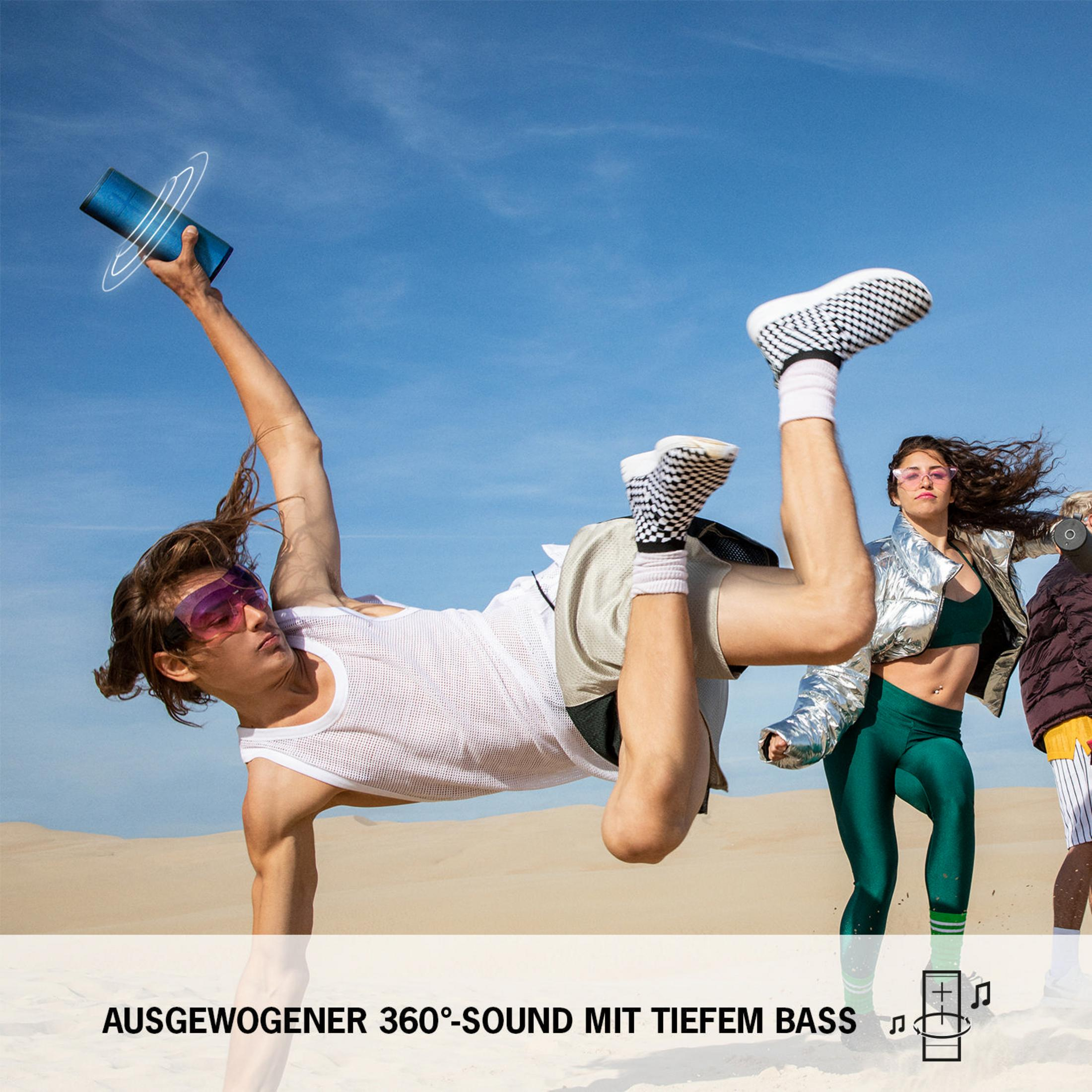 Ludzie z głośnikiem: mężczyzna w okularach, kobieta i inna osoba w tle.