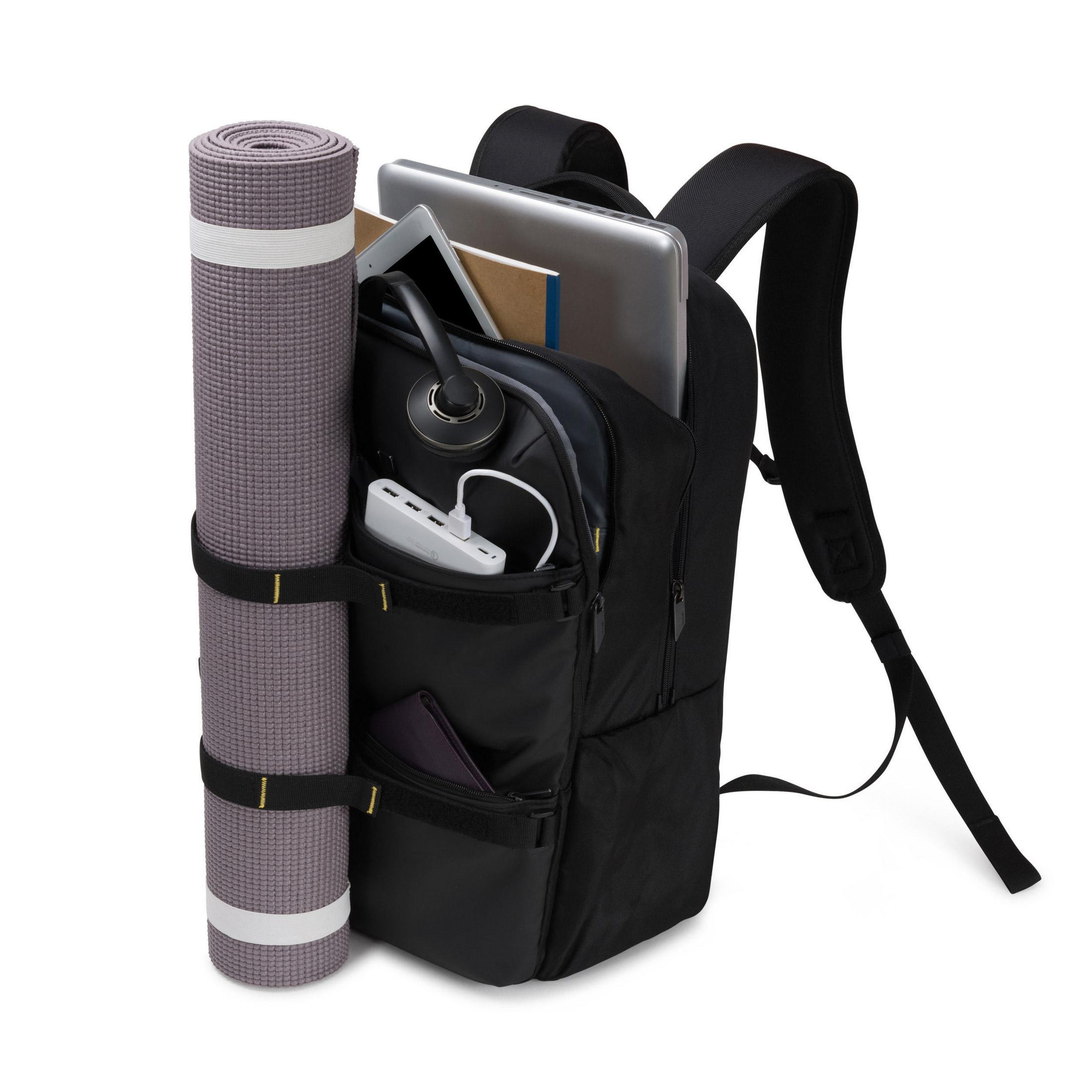 Zaino nero con tappetino yoga, tablet, cuffie e altri oggetti all'interno.