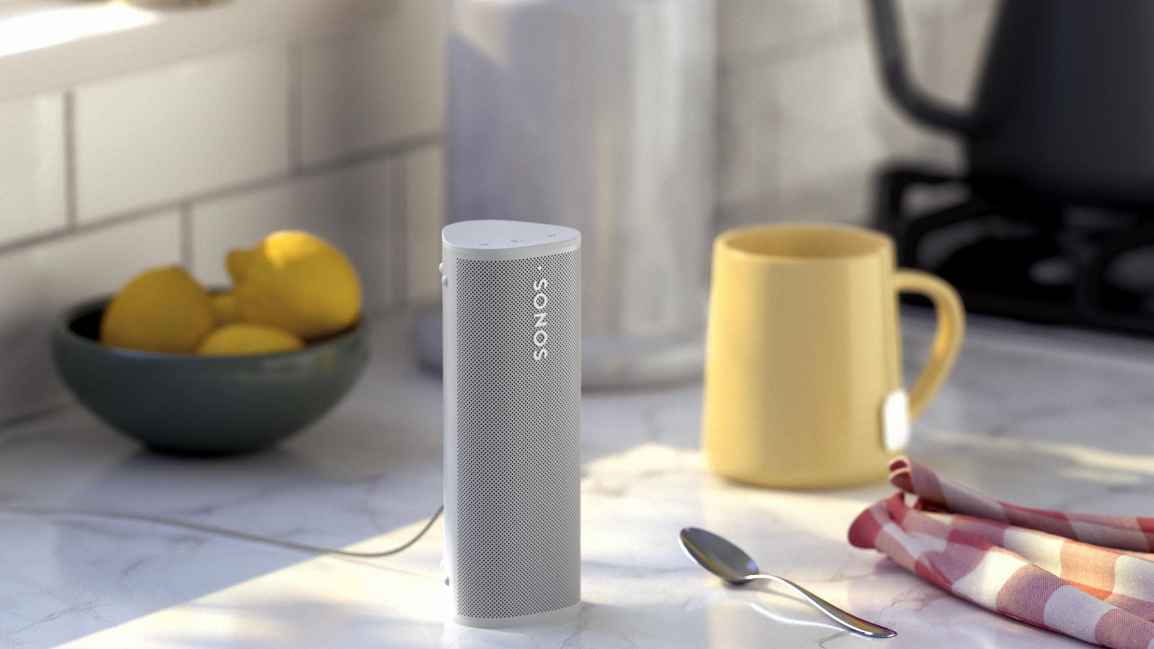 Un altavoz SONOS blanco, con una taza amarilla y limones. Un entorno de cocina.