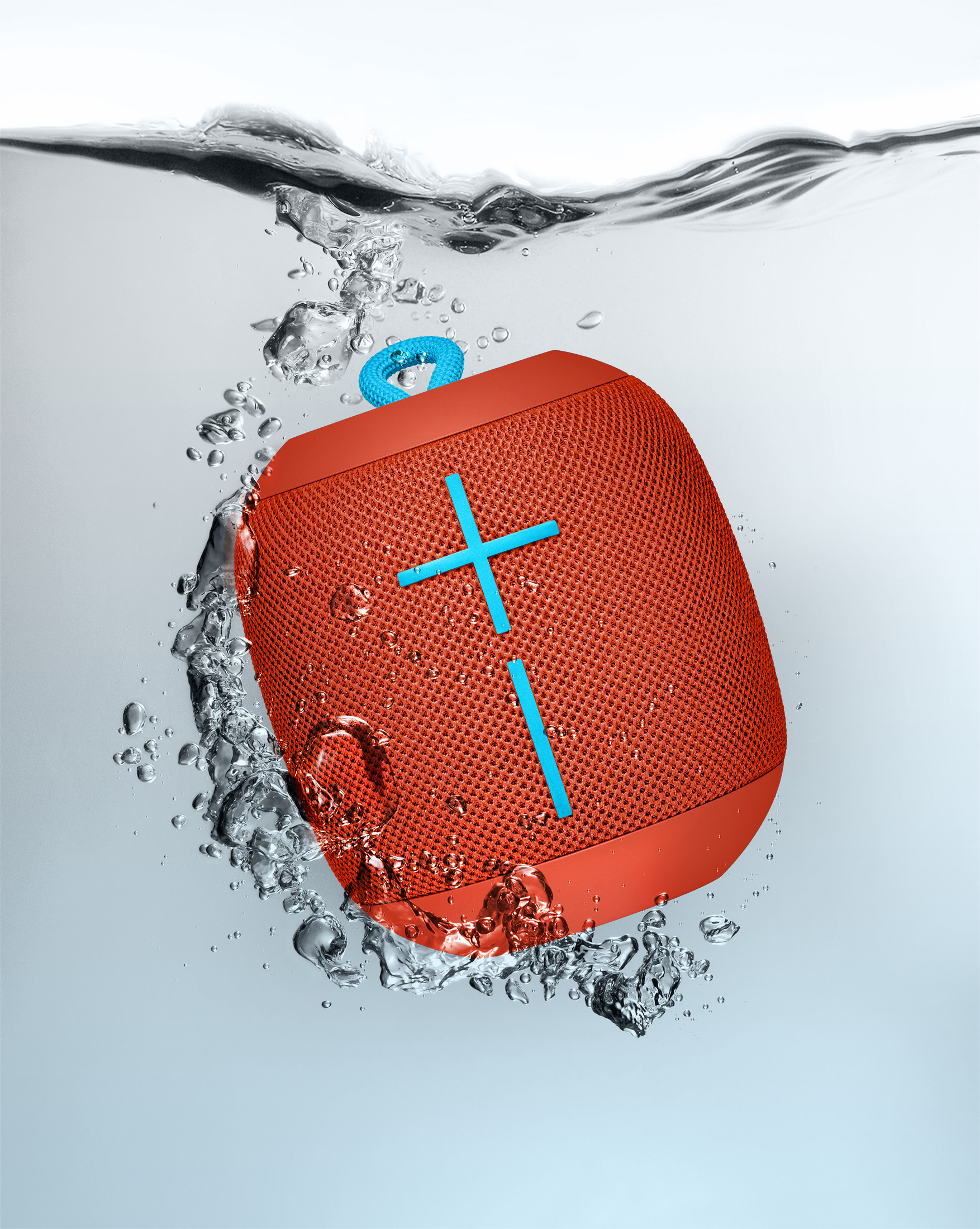 Altavoz naranja sumergido en agua con burbujas. Signo más azul en el altavoz.