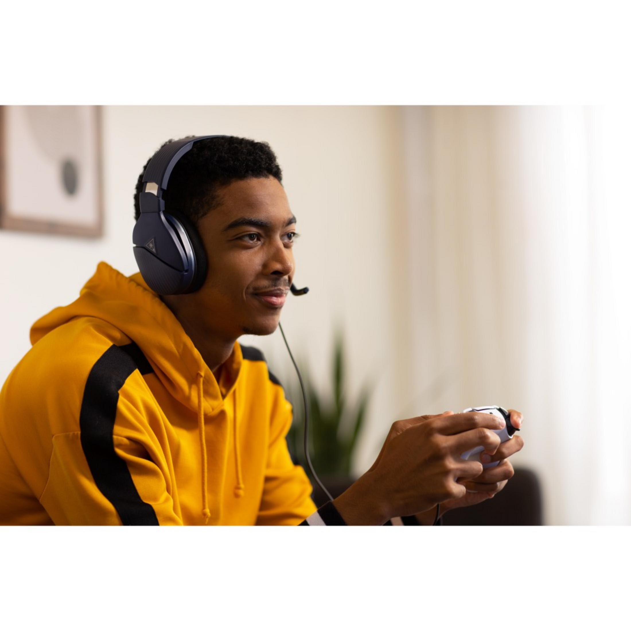 Mężczyzna w żółtej bluzie z kapturem i zestawie słuchawkowym do gier gra z kontrolerem.