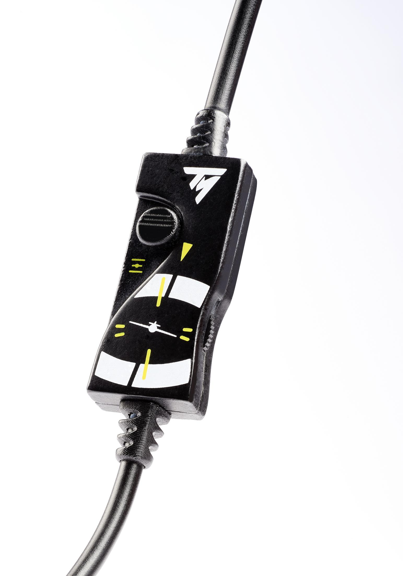 Zbliżenie czarnej jednostki sterującej. Jest przymocowana do czarnego przewodu. Białe tło.