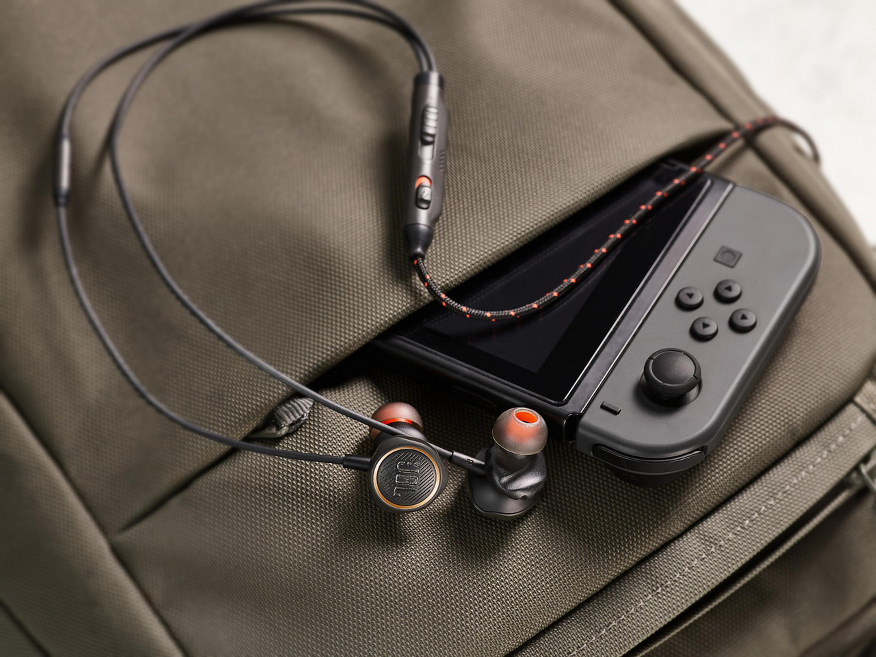 Auriculares con consola de juegos dentro del bolsillo de una mochila.