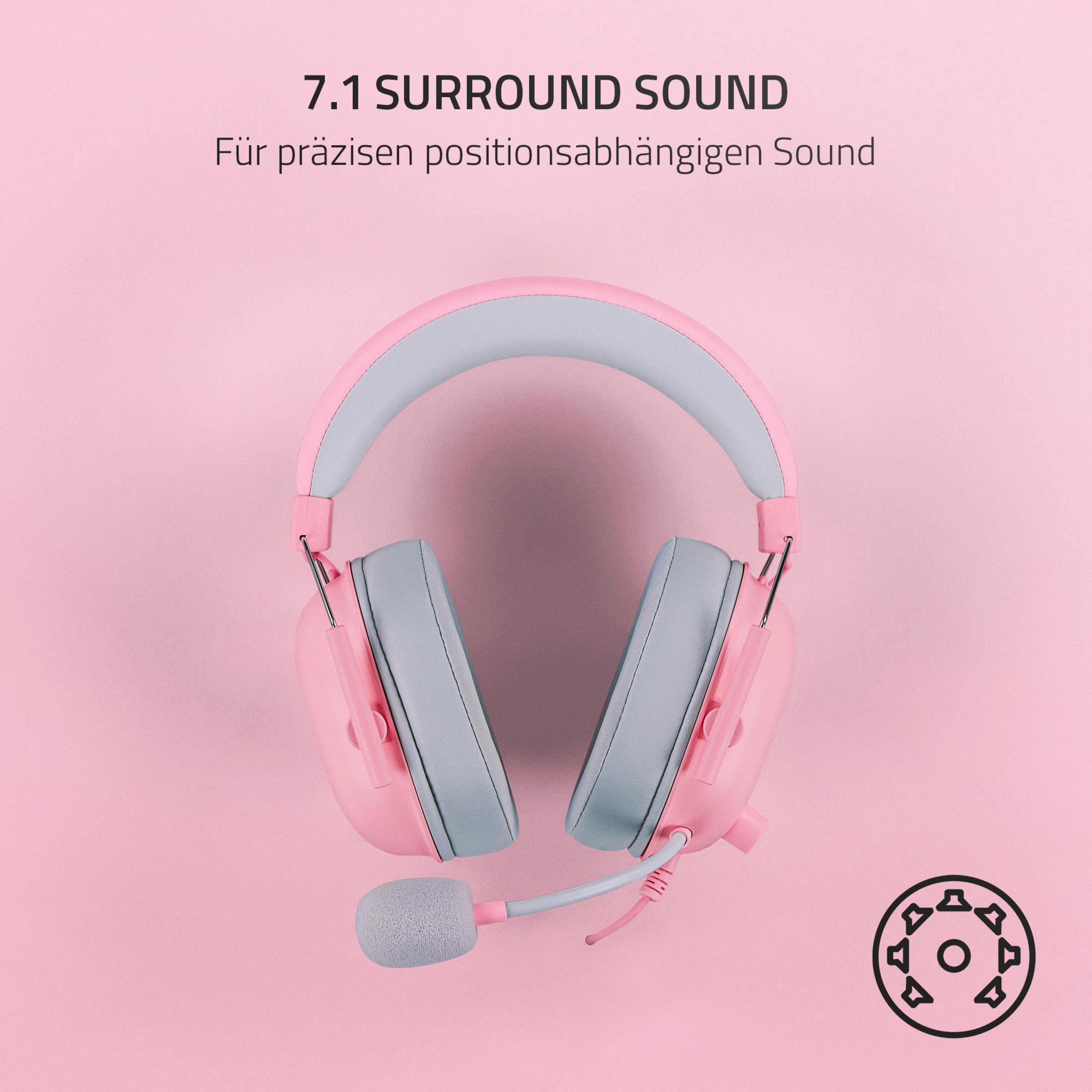 Różowy i szary zestaw słuchawkowy do gier na różowej powierzchni, z tekstem.