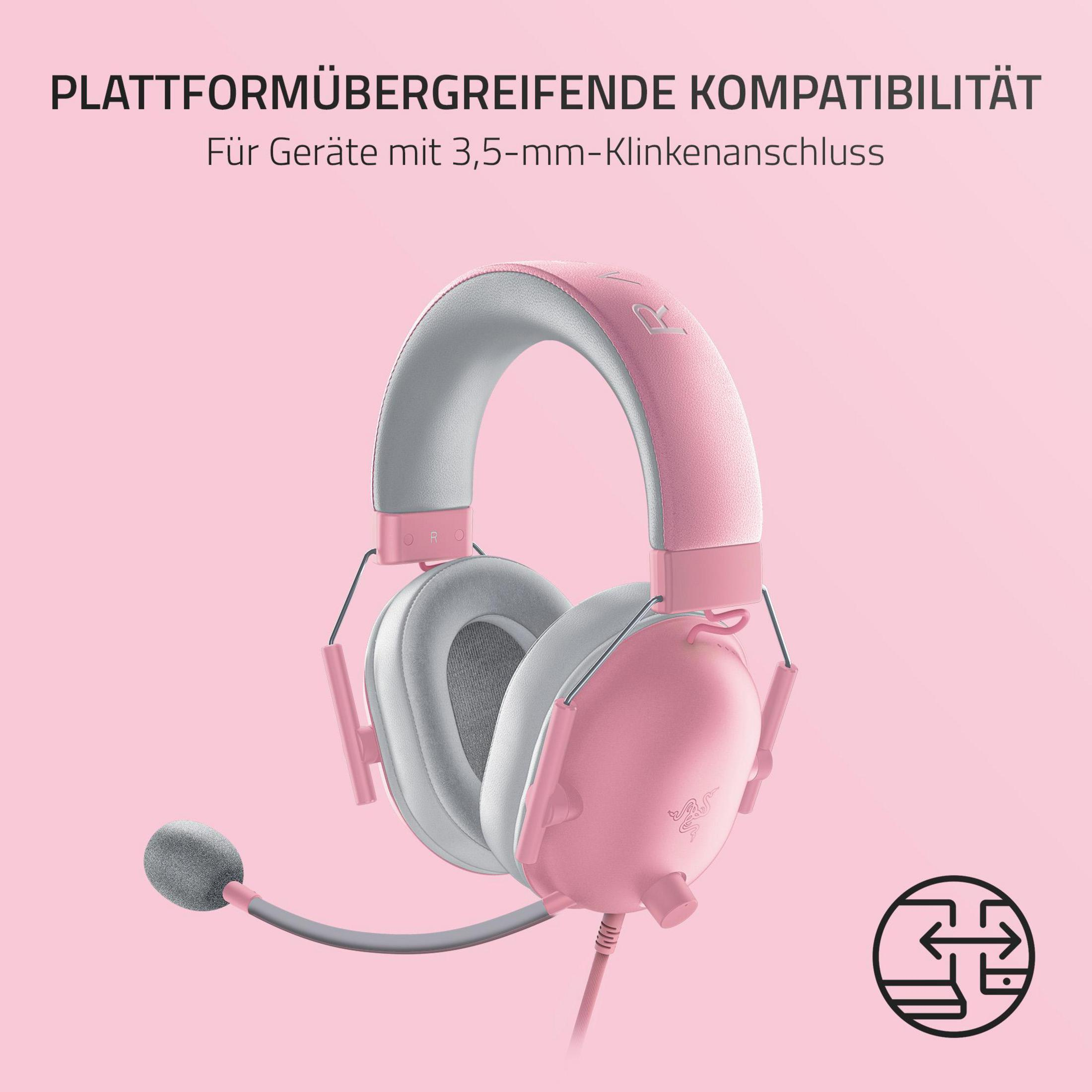 Różowe słuchawki dla graczy Razer z tekstem, na różowym tle. Widoczny jest mały szary mikrofon.