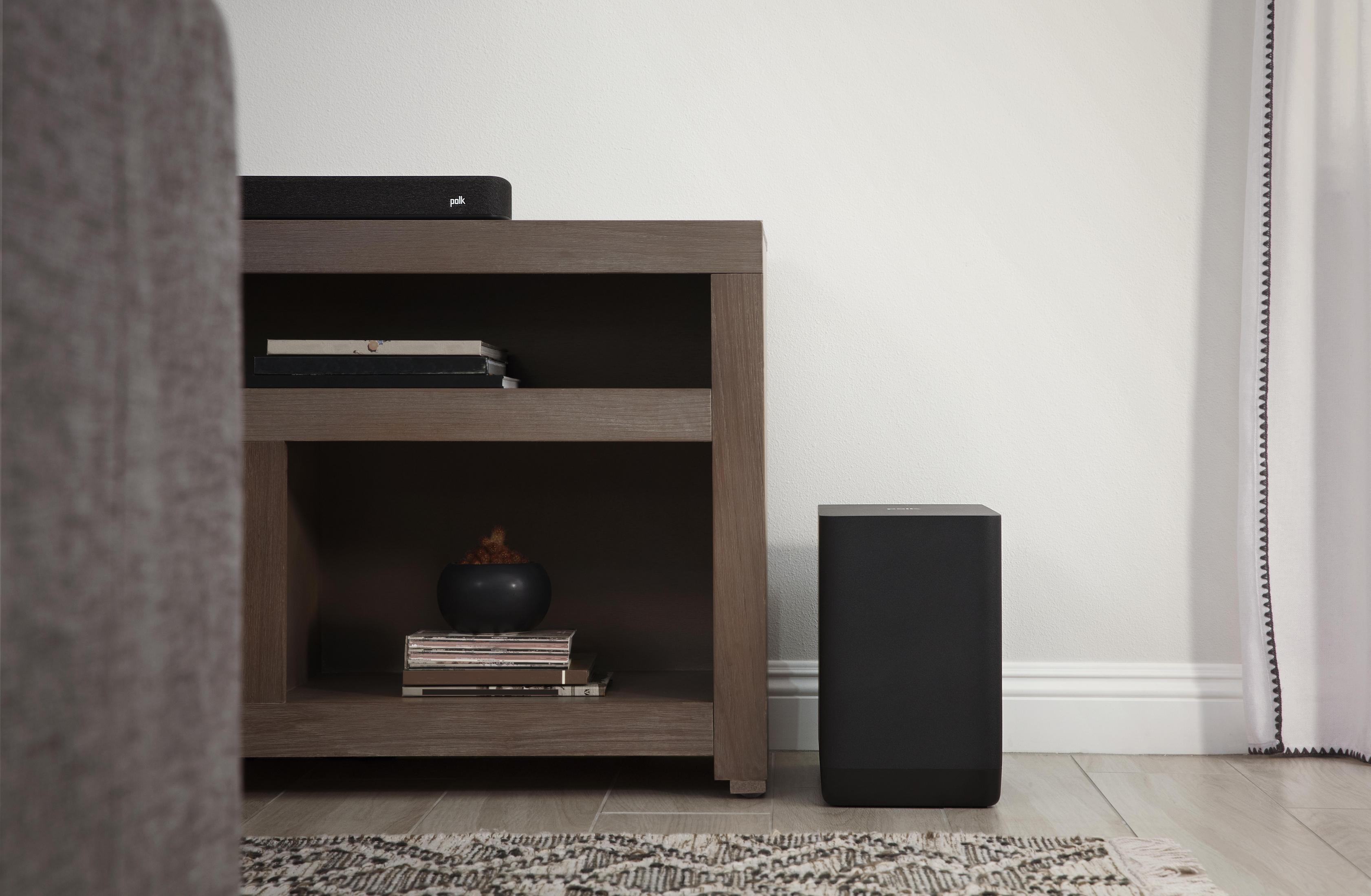 Wohnzimmer mit schwarzer Soundbar, Subwoofer und Dekorationen.