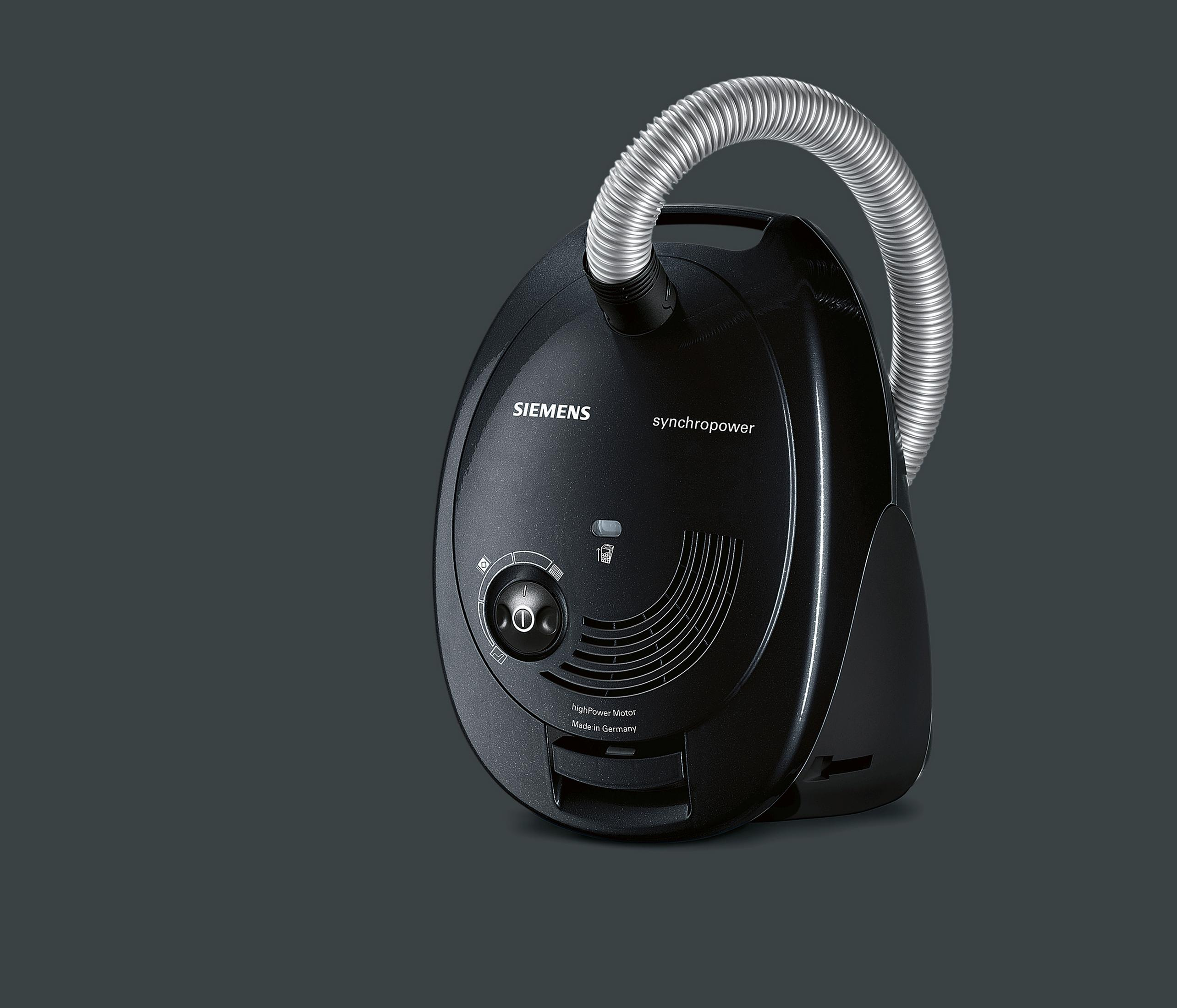 Czarny odkurzacz, pod kątem na ciemnoszarym tle, z widoczną nazwą marki.
