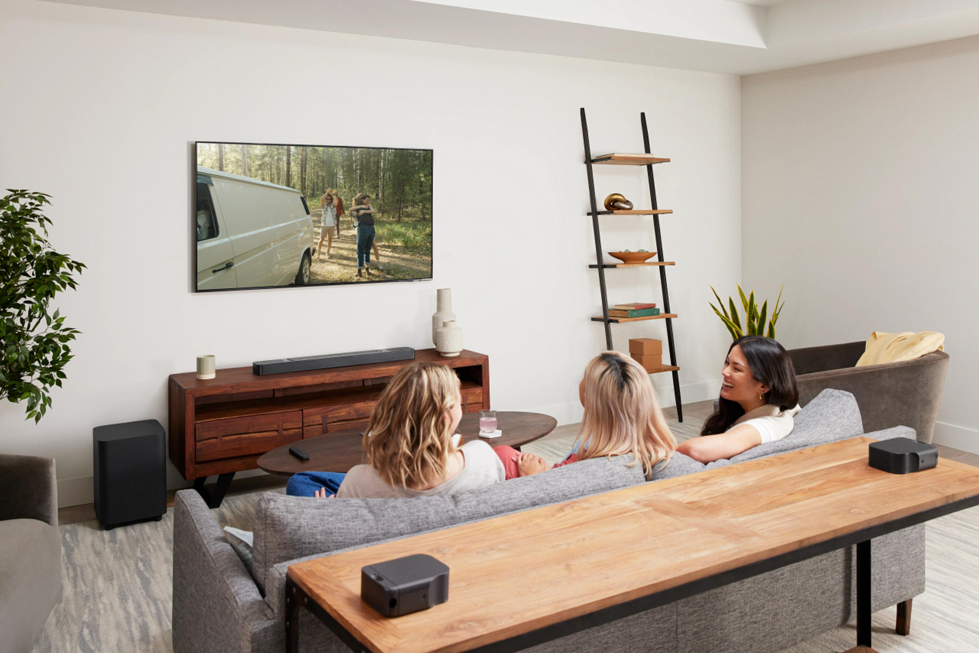 Persone che guardano la TV in soggiorno. La TV mostra un furgone in una foresta.