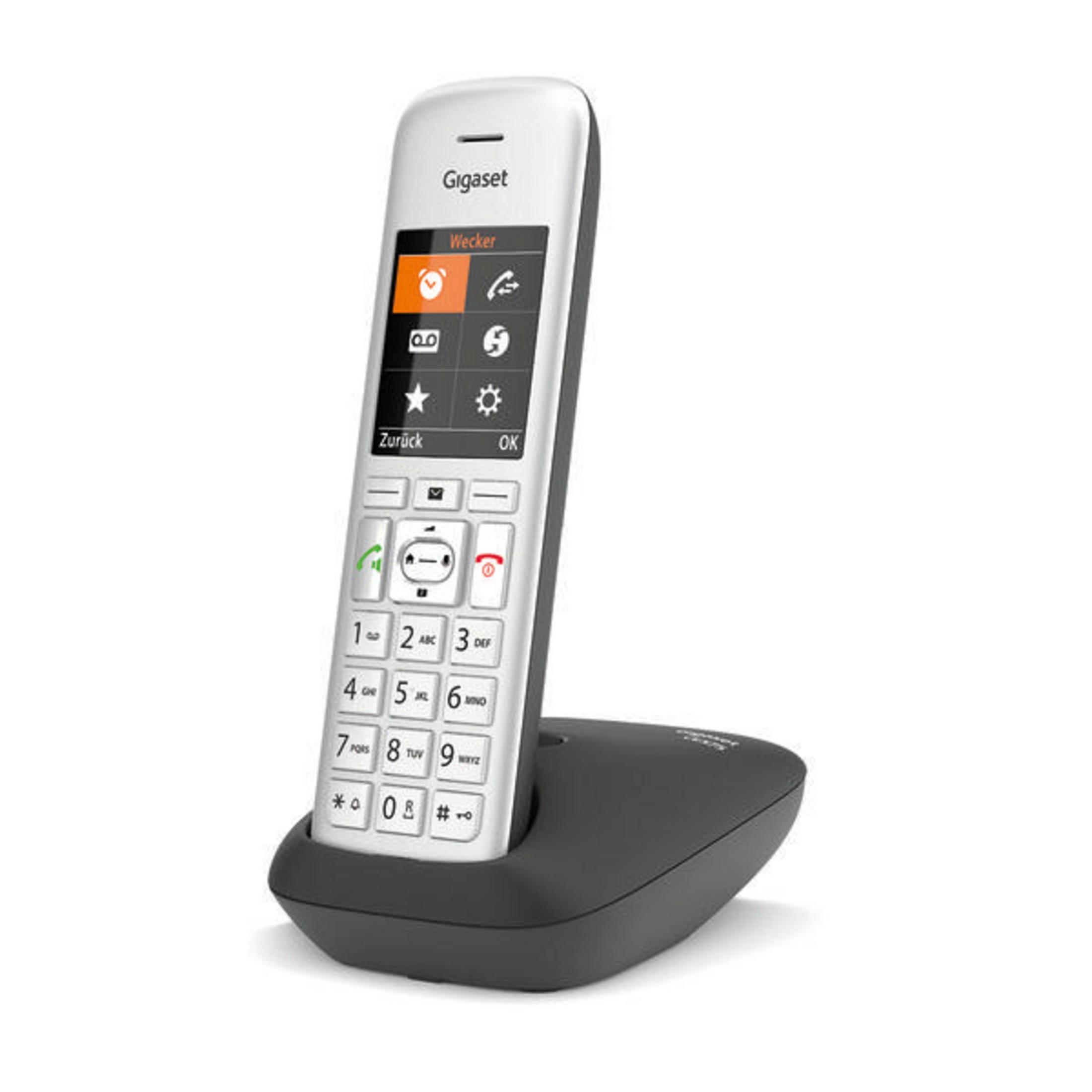 Weißes Gigaset-Telefon auf seiner Ladestation. Weißer Hintergrund.