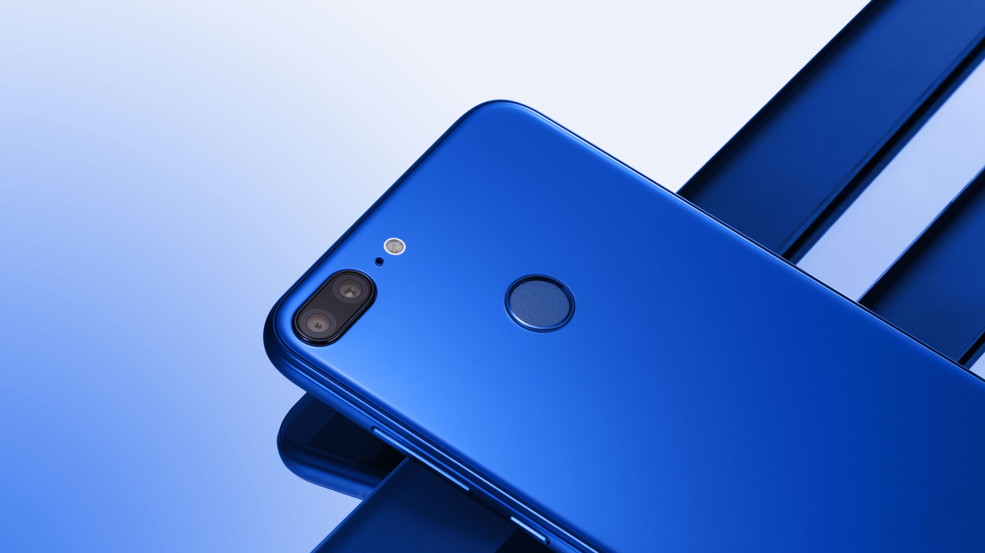 Blaues Telefon, Rückansicht, mit Dual-Kamera und Fingerabdrucksensor auf blauer Oberfläche.