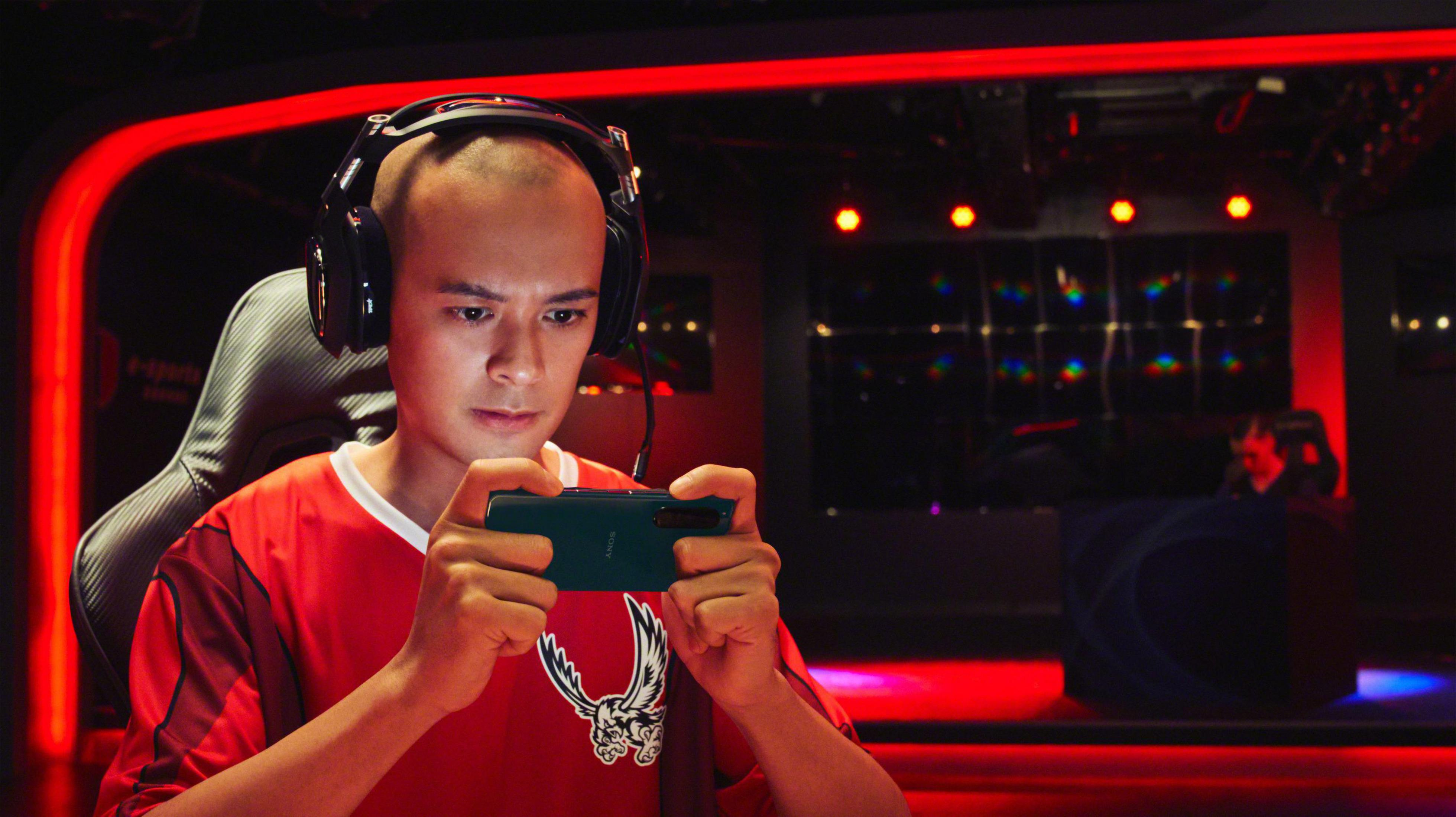 Gracz grający w grę na urządzeniu przenośnym w słuchawkach.