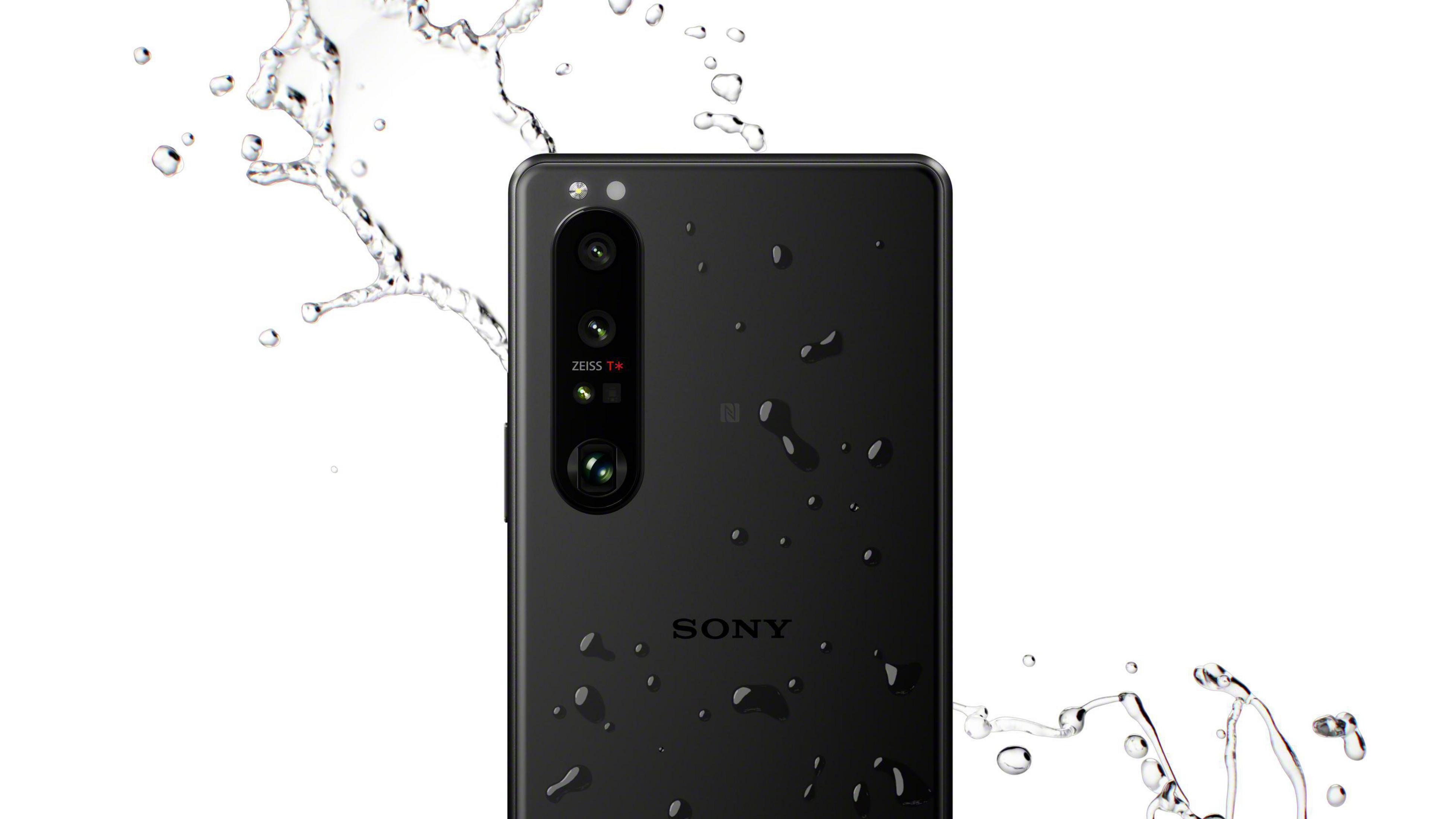 Schwarzes Telefon mit mehreren Kameras und Wassertropfen auf weißem Hintergrund.