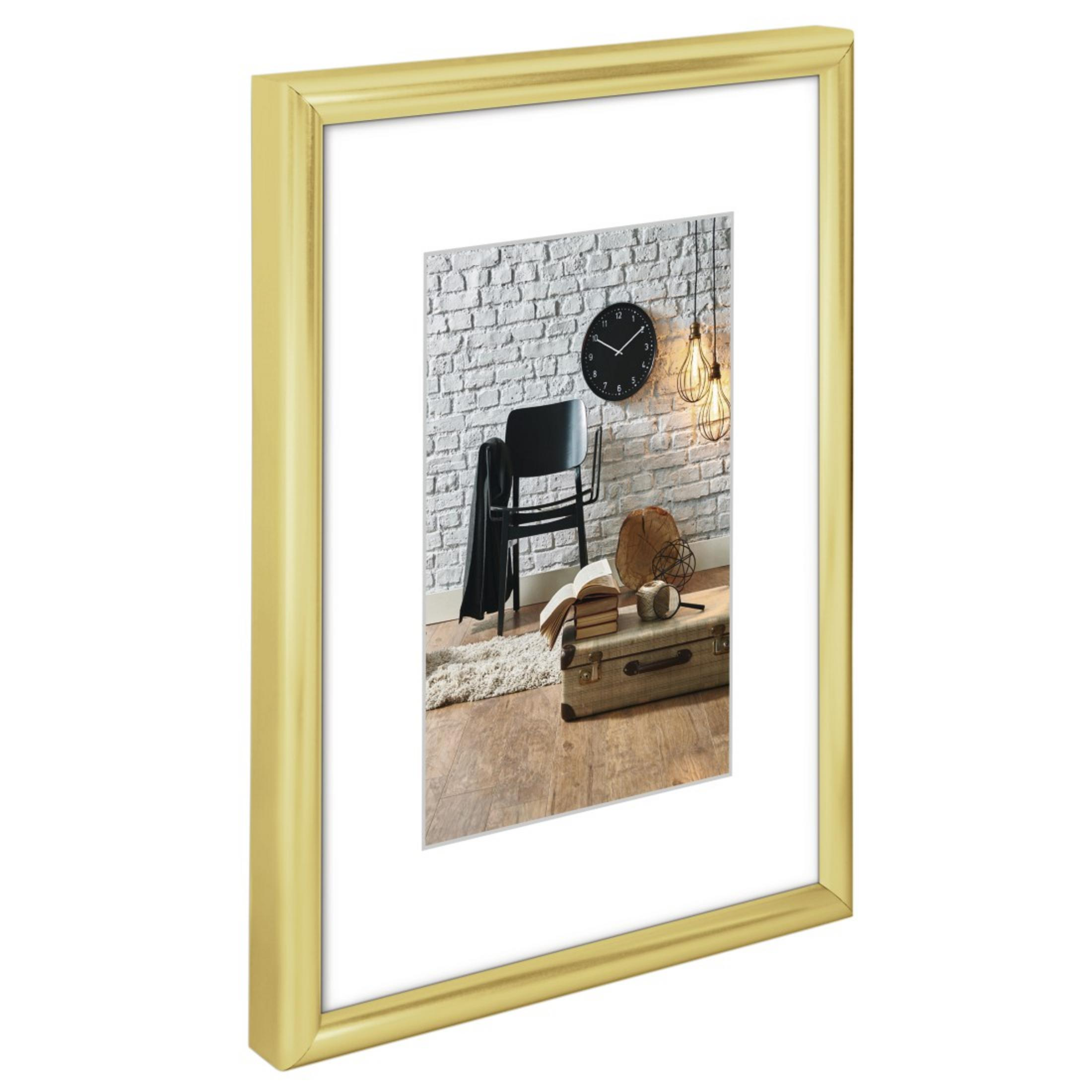 Goldgerahmtes Bild, Innenaufnahme mit Uhr, Stuhl und Vintage-Koffer.
