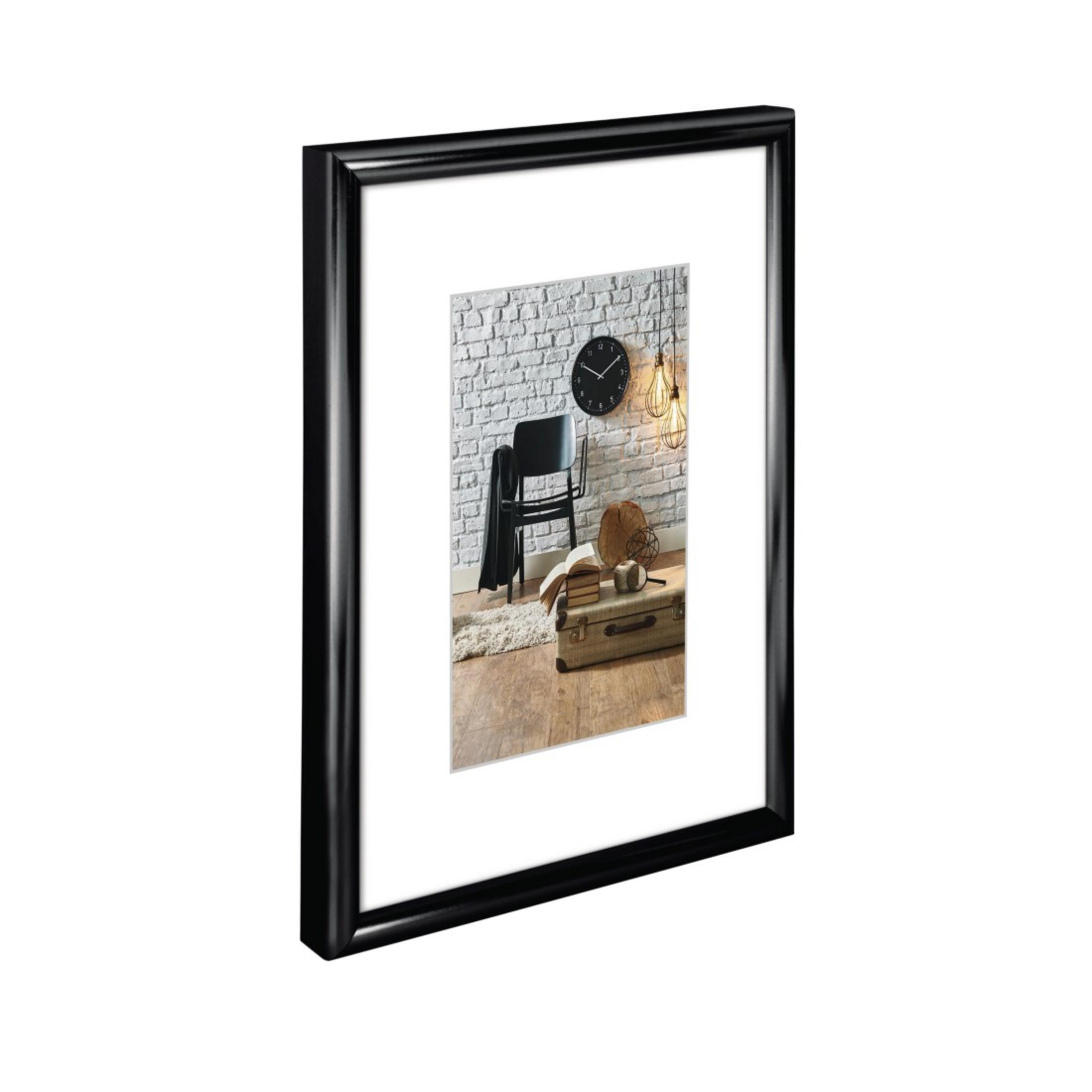 Image encadrée avec un cadre noir, dans un cadre de pièce avec une horloge et une chaise.