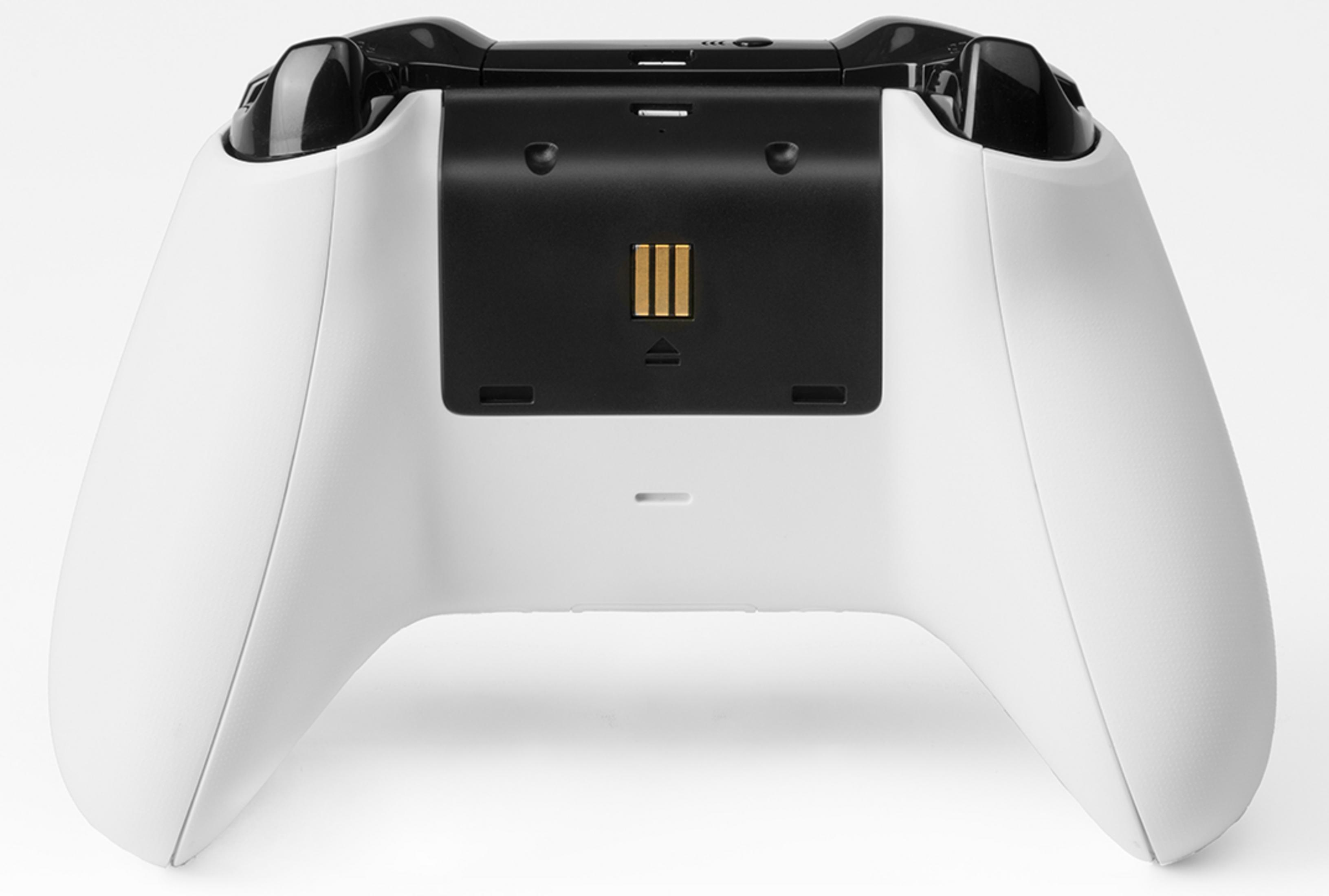 Tył białego kontrolera Xbox z portem USB i przegródką na baterie na białym tle.