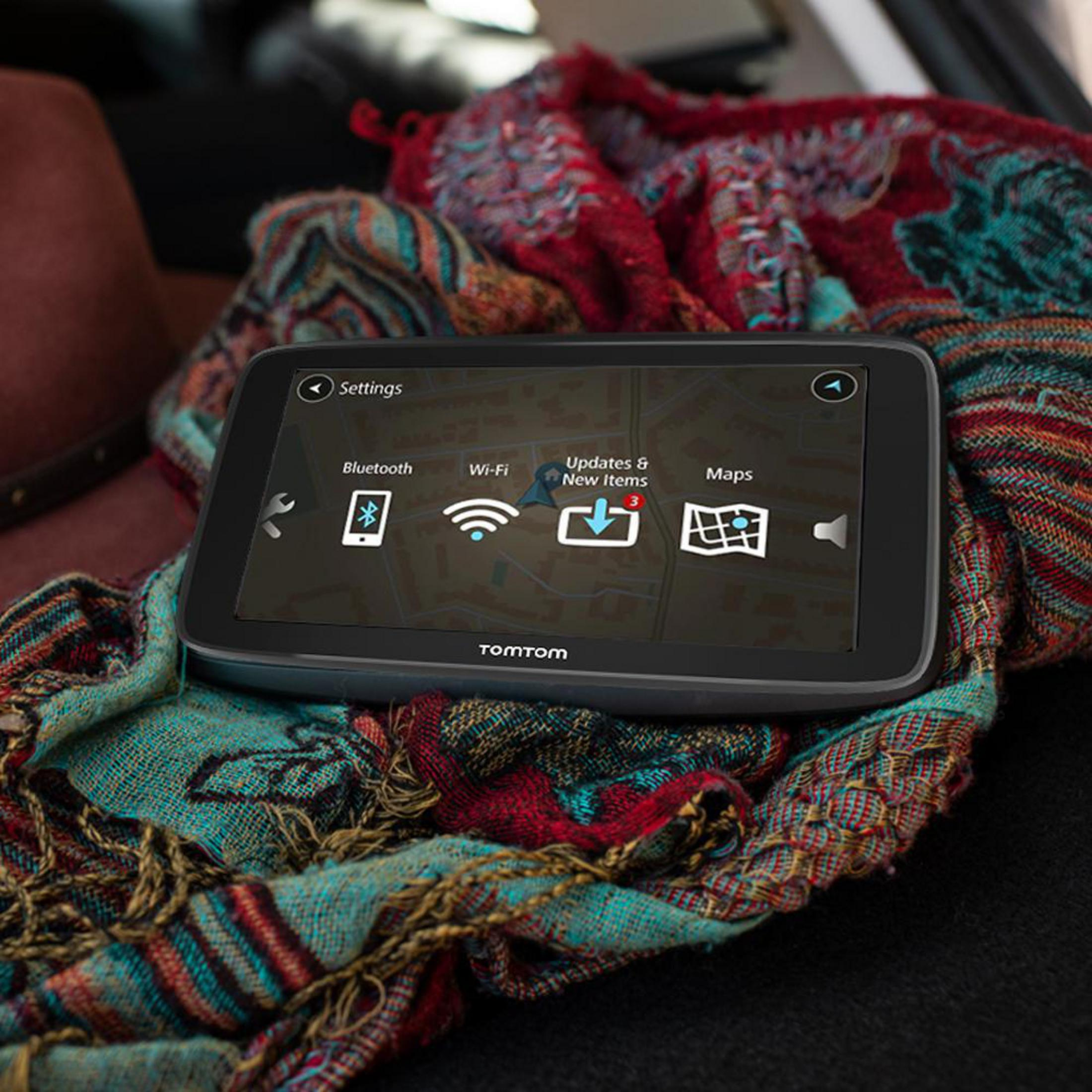 GPS-Gerät auf einem bunten Schal. Der Bildschirm zeigt Einstellungen und Kartenoptionen.
