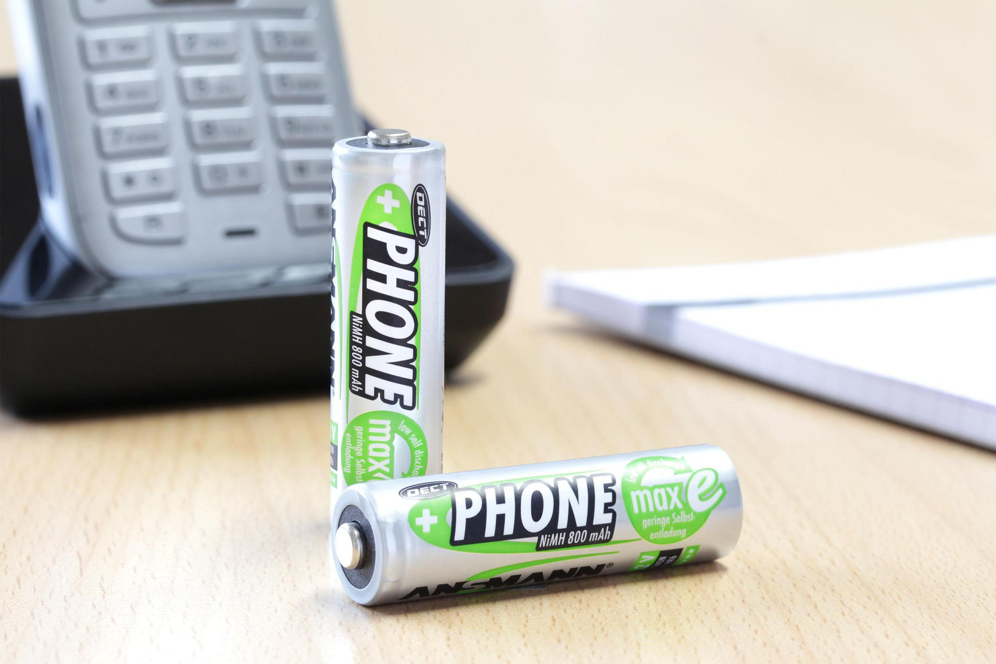 Due batterie AA con testo PHONE max. Una batteria è appoggiata all'altra.