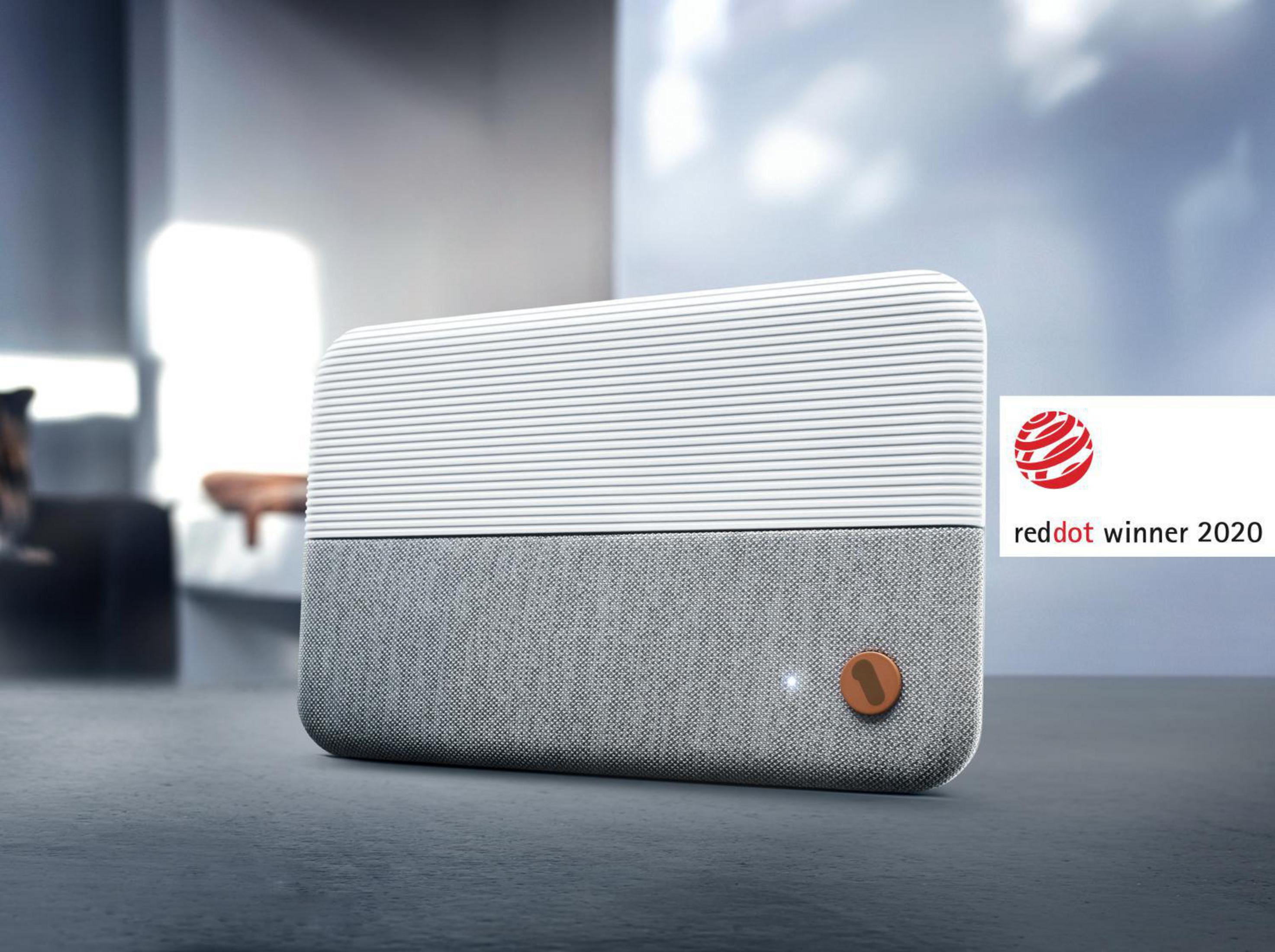 Nowoczesny głośnik z białą górą i szarą podstawą, z logo Red Dot Award.