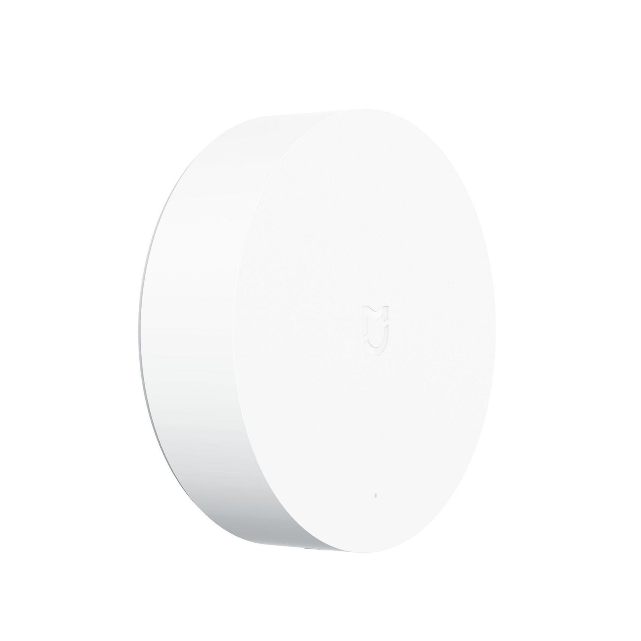 Un dispositivo per la casa intelligente bianco e rotondo. Ha un design minimalista con un piccolo logo sul davanti.