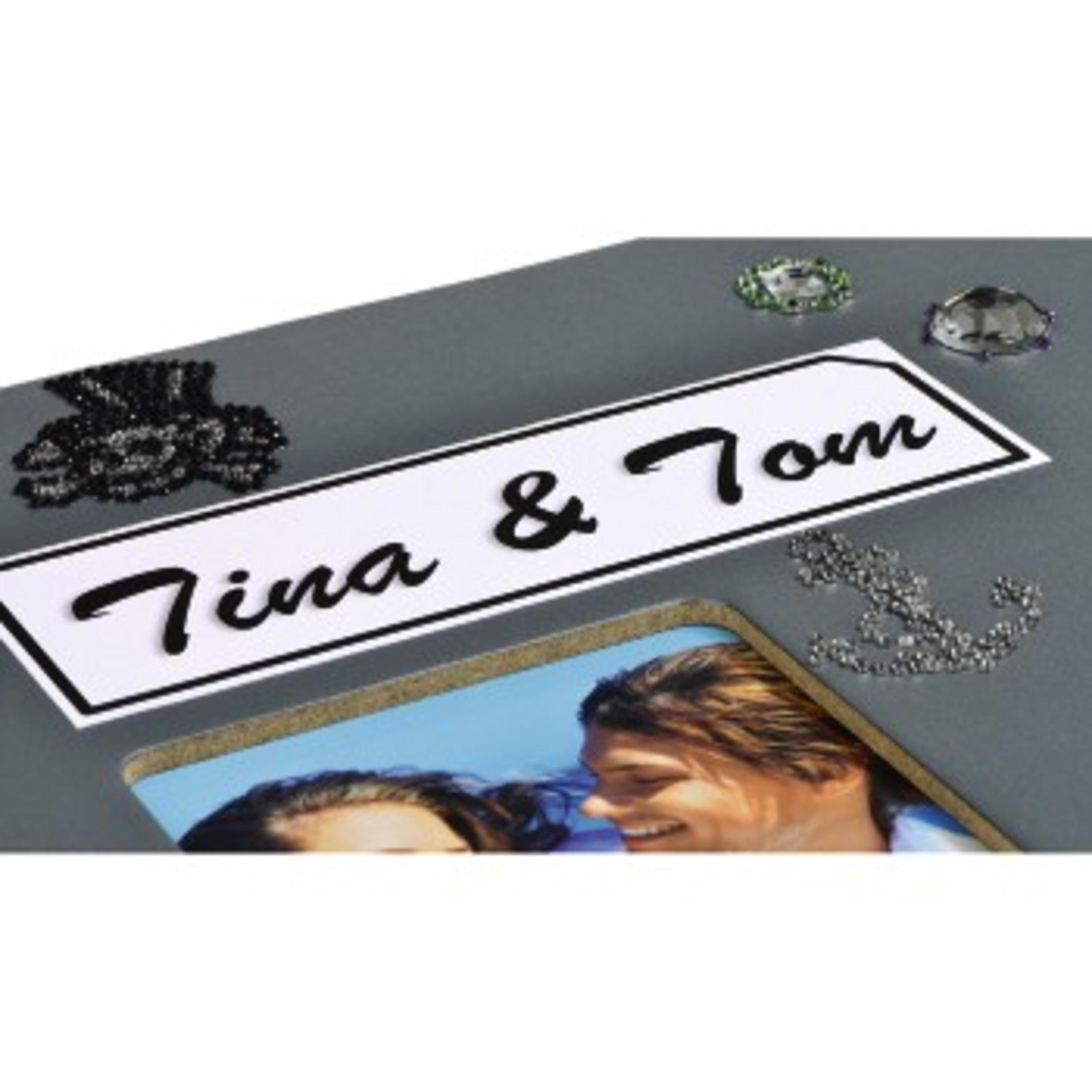 Zbliżenie zdjęcia. Tekst 'Tina & Tom' na białym prostokącie, otoczony ozdobami.