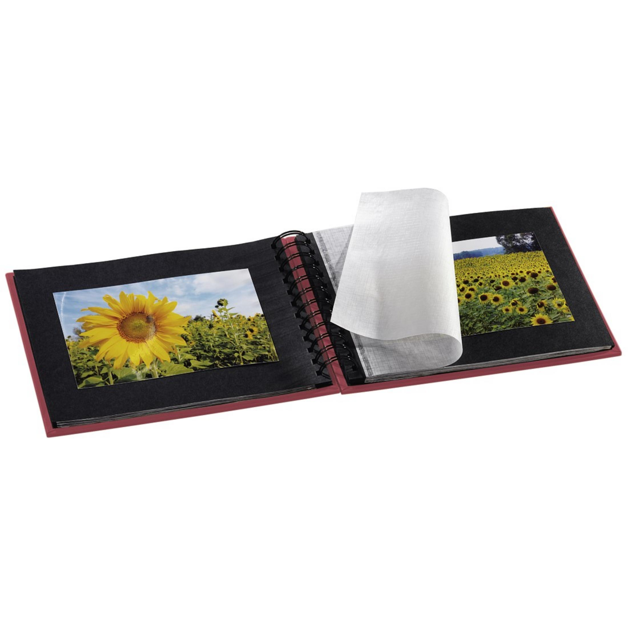 Otwarty album ze zdjęciami słoneczników, z białą kartką papieru.