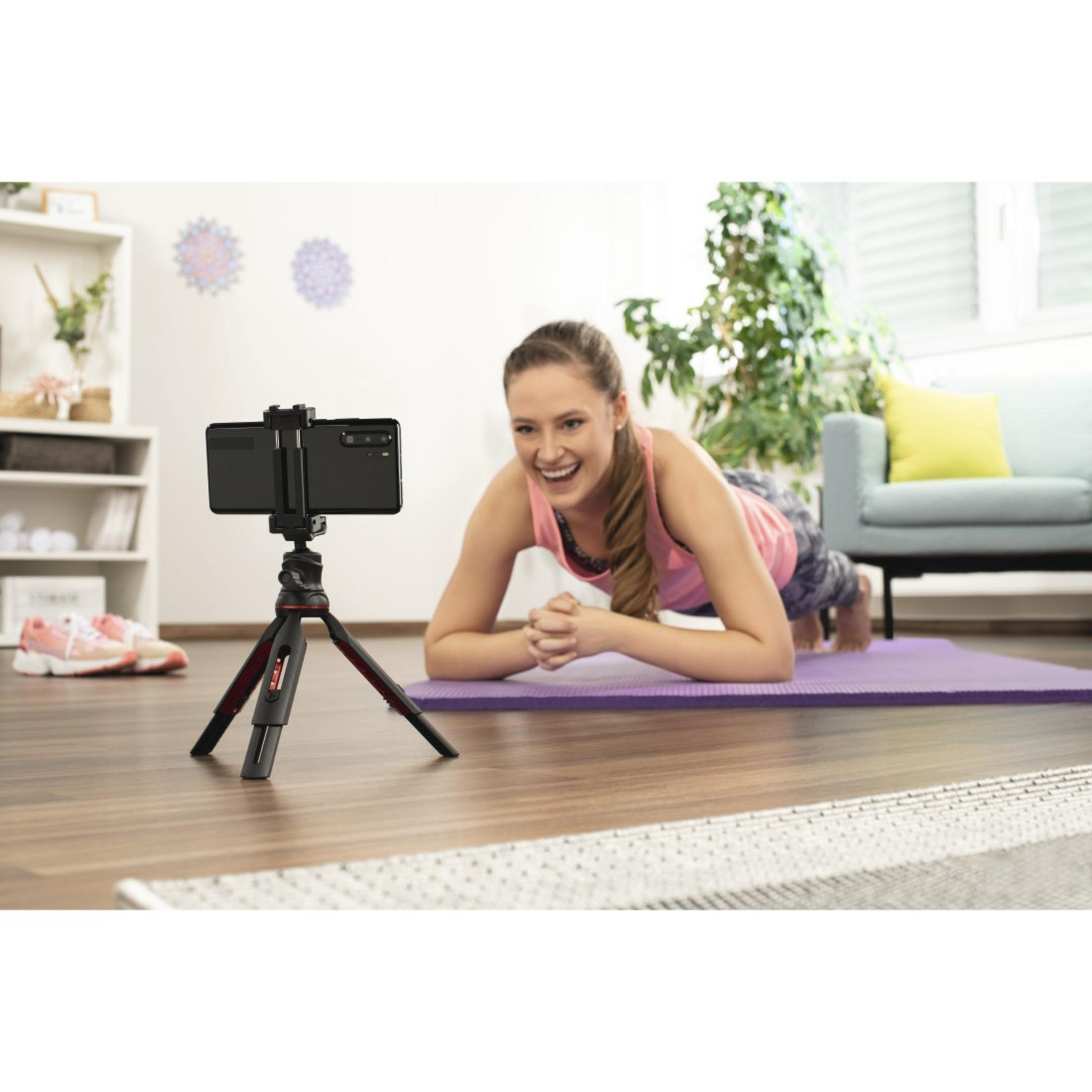 Frau macht Plank-Übung, nimmt Video auf, auf einer Matte.