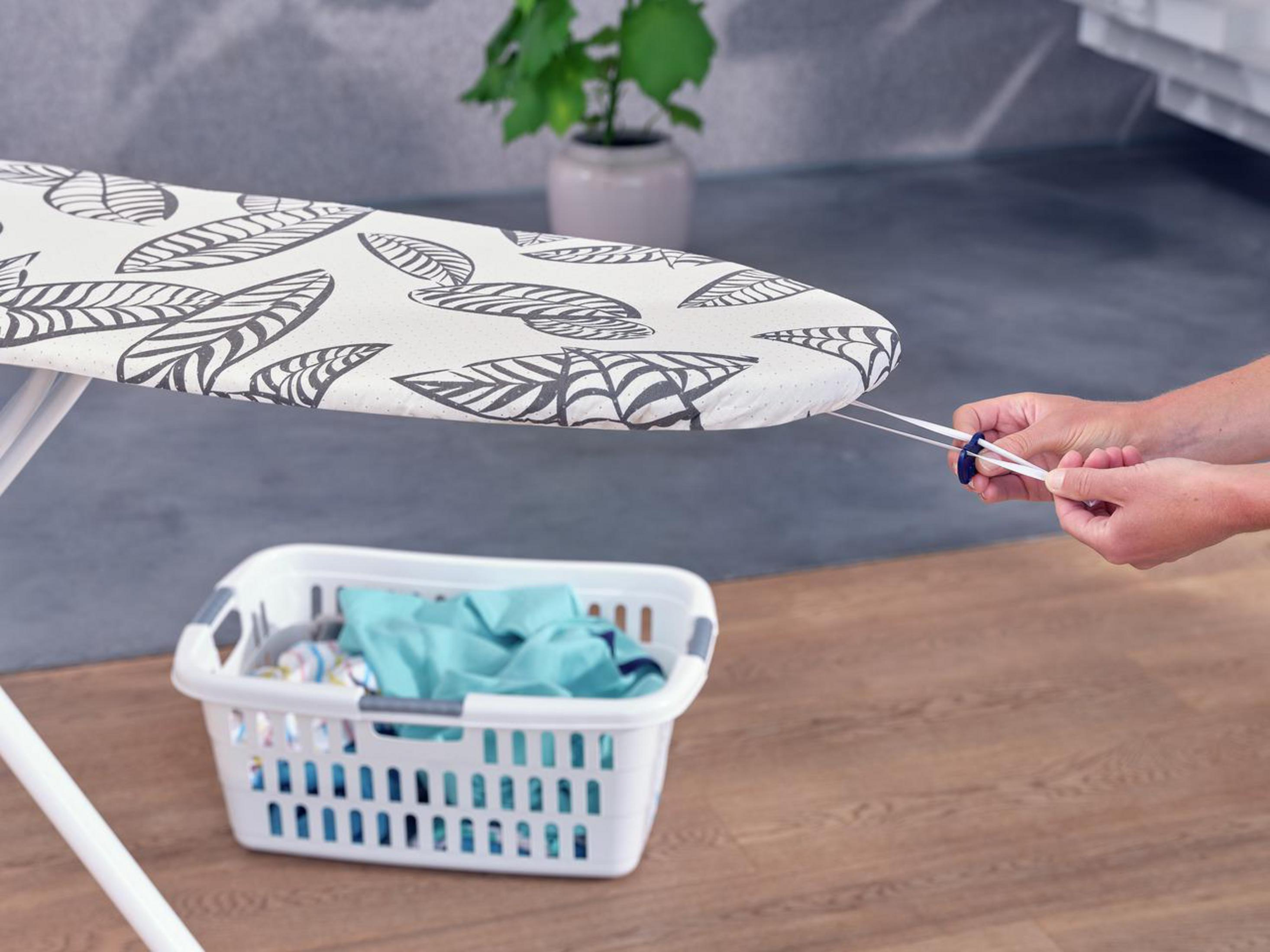 Deska do prasowania ze wzorem liści. Ręce pociągają za sznurek.