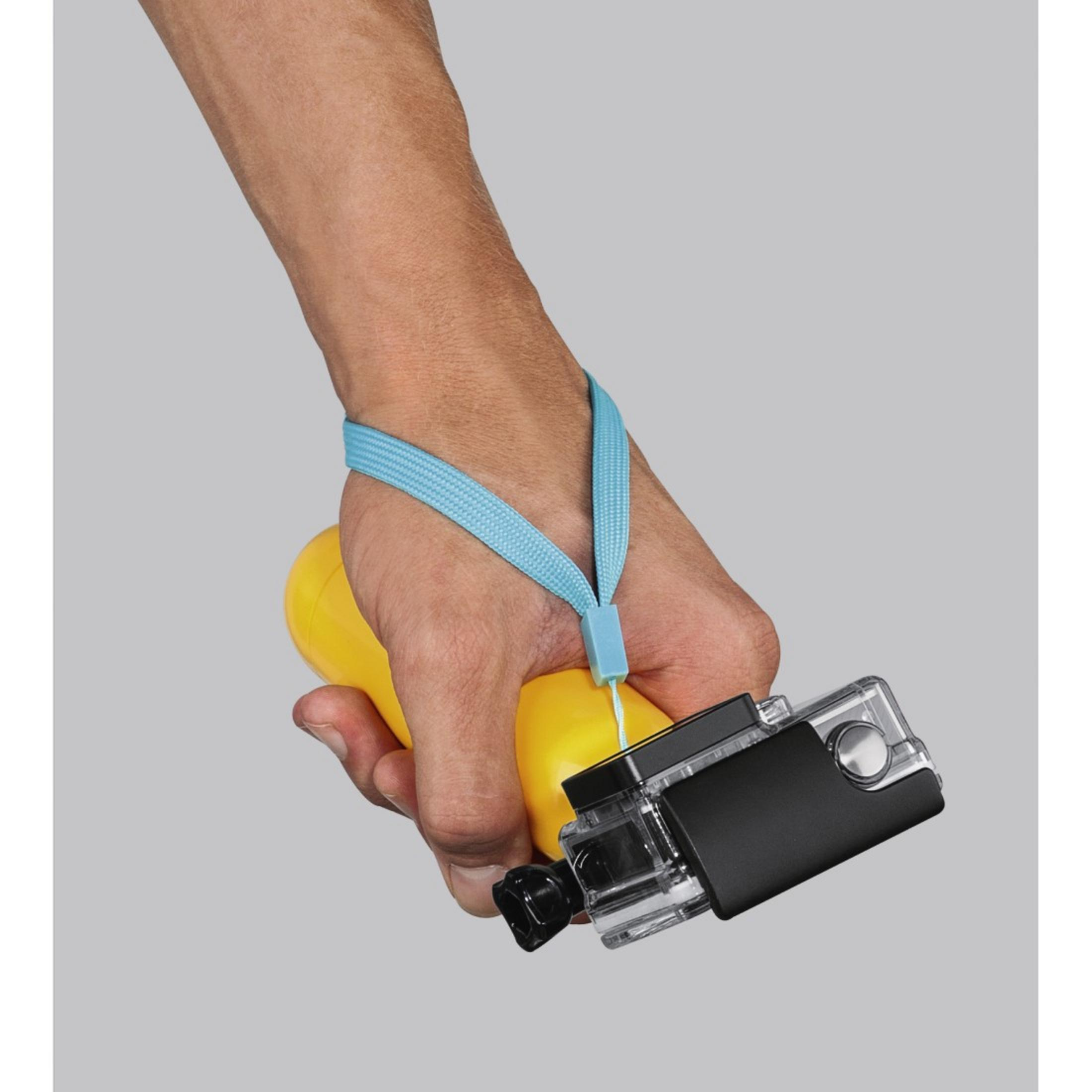 Ręka trzymająca żółte urządzenie z dołączoną kamerą i niebieskim paskiem na nadgarstek.